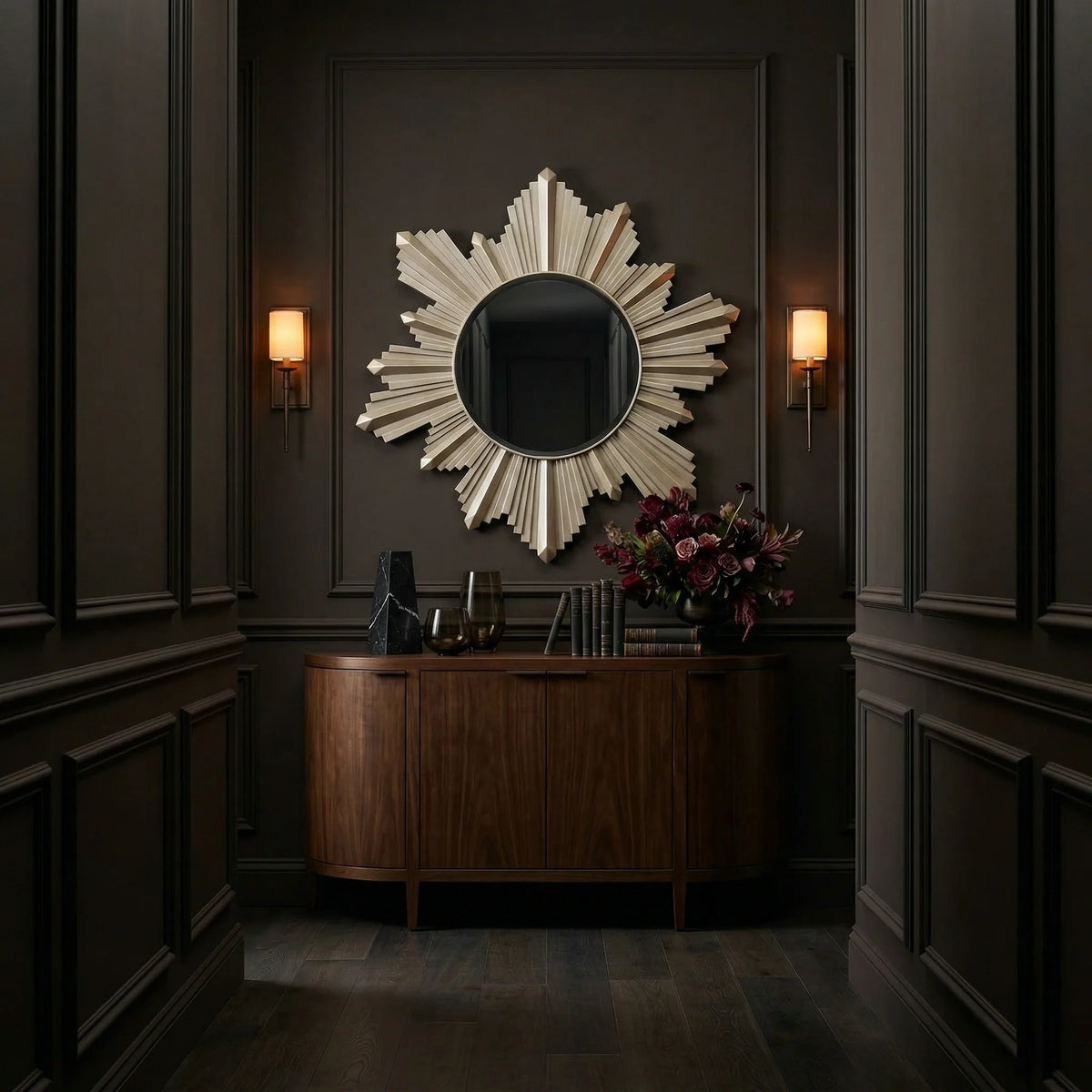 Ambella Home Vassar sunburst wall mirror, 37W x 2D x 40H, mounted over a curved wood console in a moody luxury hallway interior