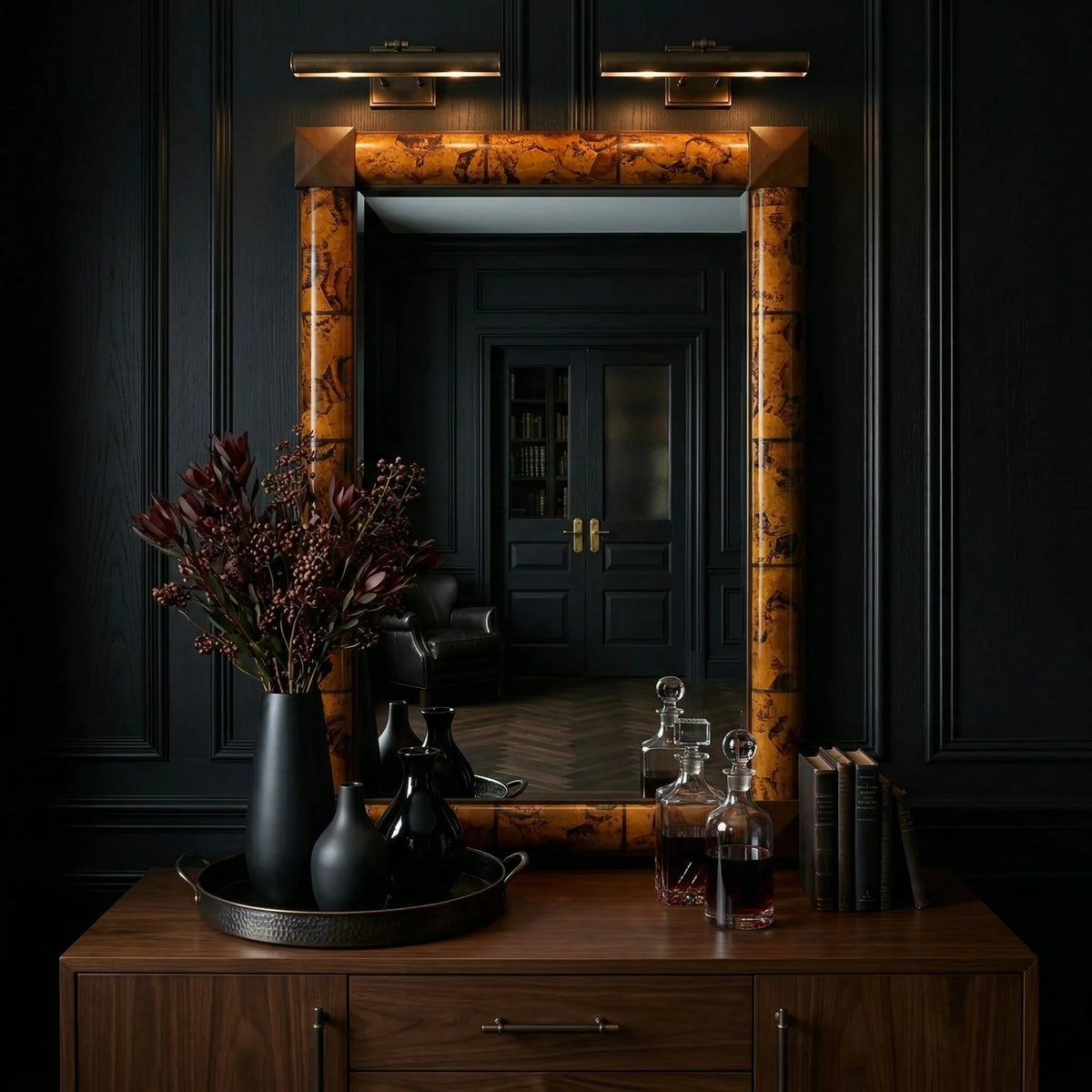 Rectangular Delancy Mirror by Ambella Home with tortoise shell finish and geometric corner accents, styled over a walnut credenza in a dramatic dark hallway