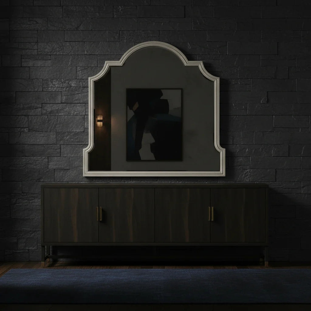 Decorative mirror on a dark brick wall with a wooden cabinet below.