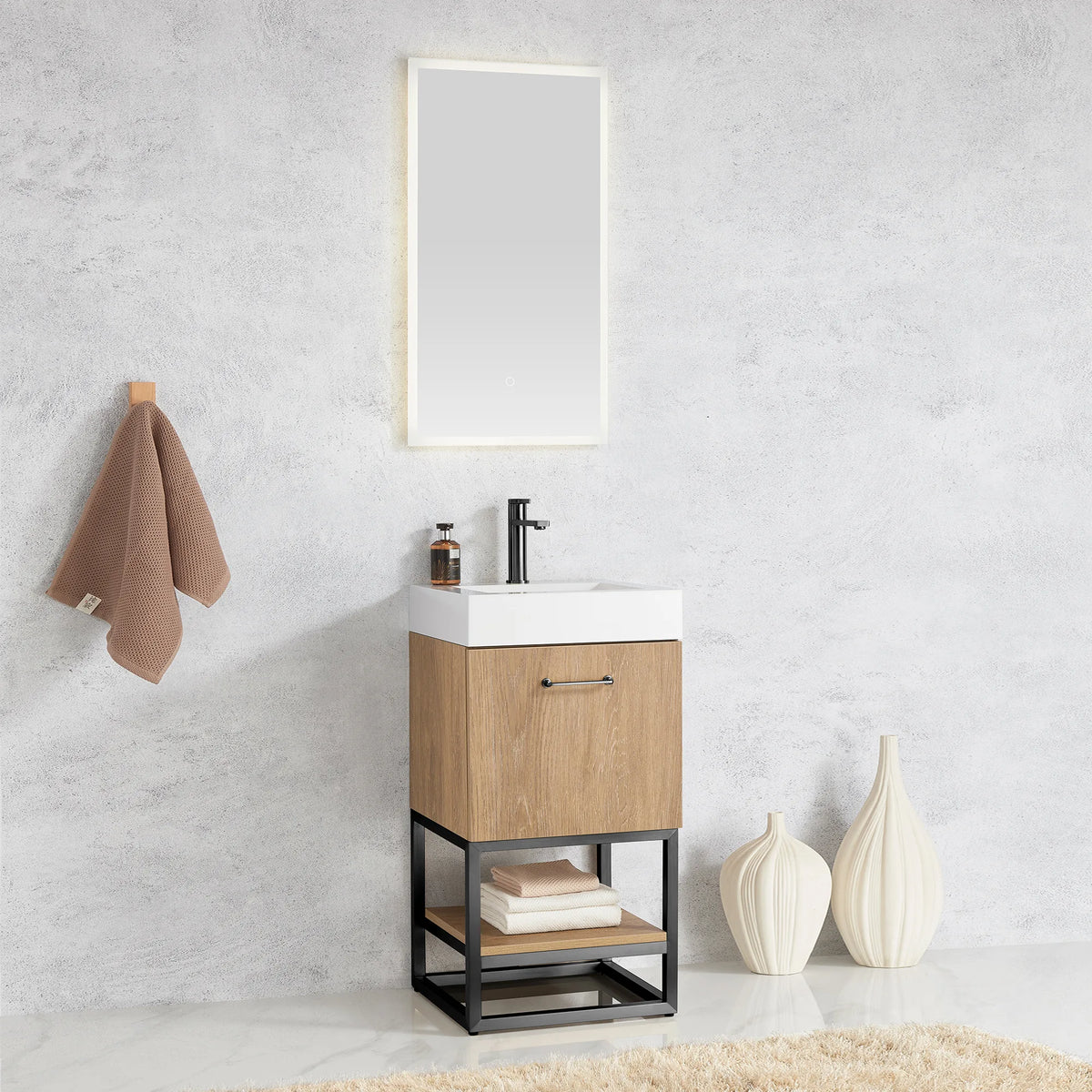 Wide shot of the oak vanity under a lit mirror with towel and cream vases close by