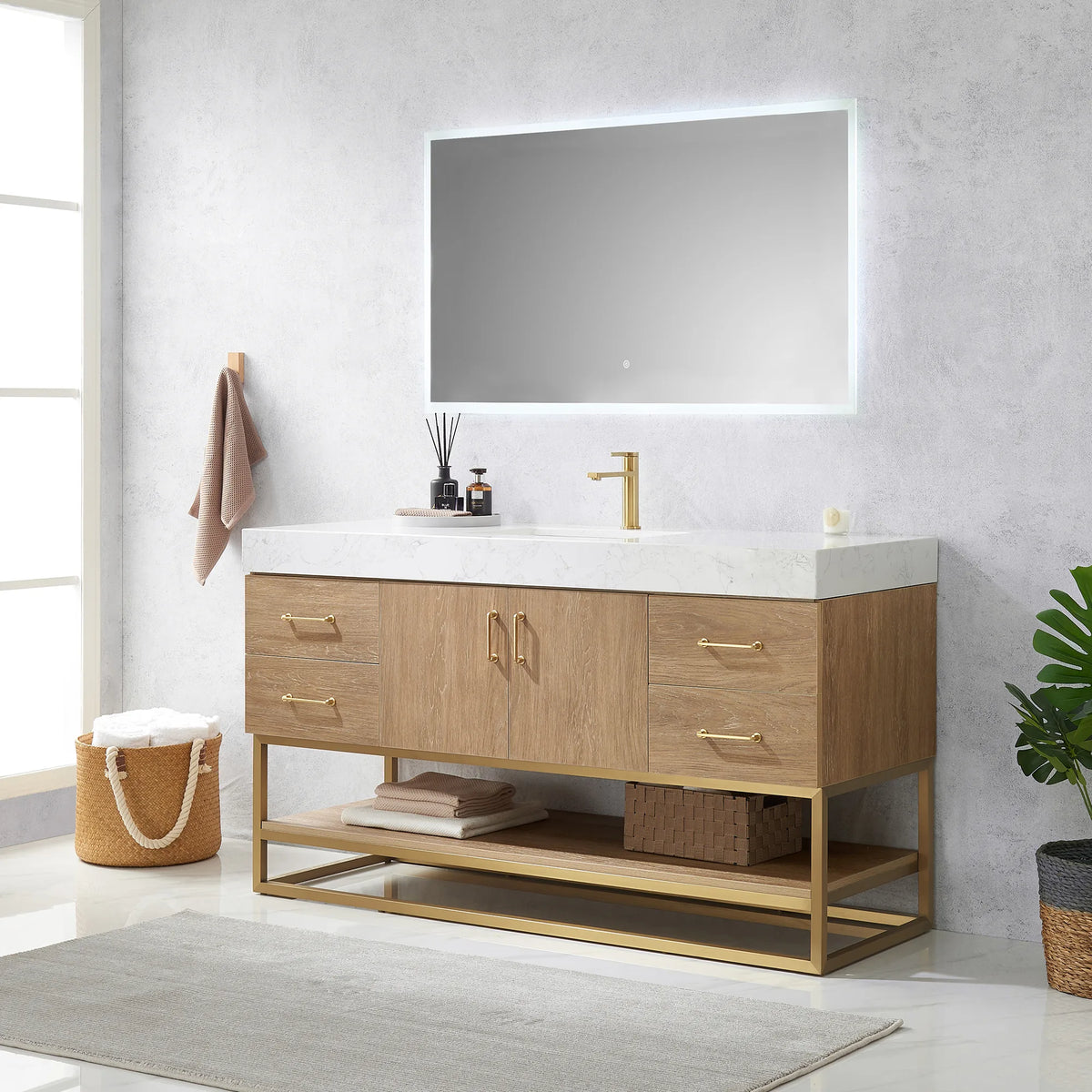Room view of the single vanity with LED mirror, wall hook towel, diffuser, basket and plant