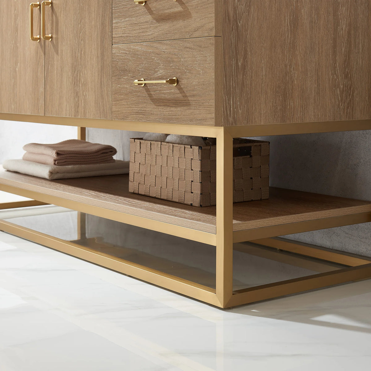 Detail of the open oak shelf with towels and basket, gold metal base and one pull above