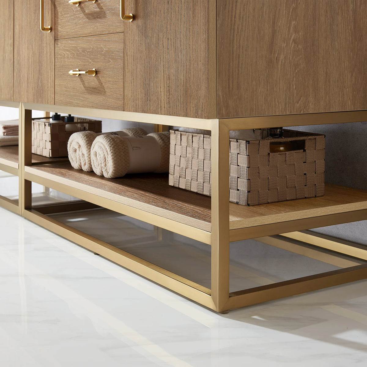 Low-angle detail of the open shelf with rolled towels and woven baskets above a gold metal base