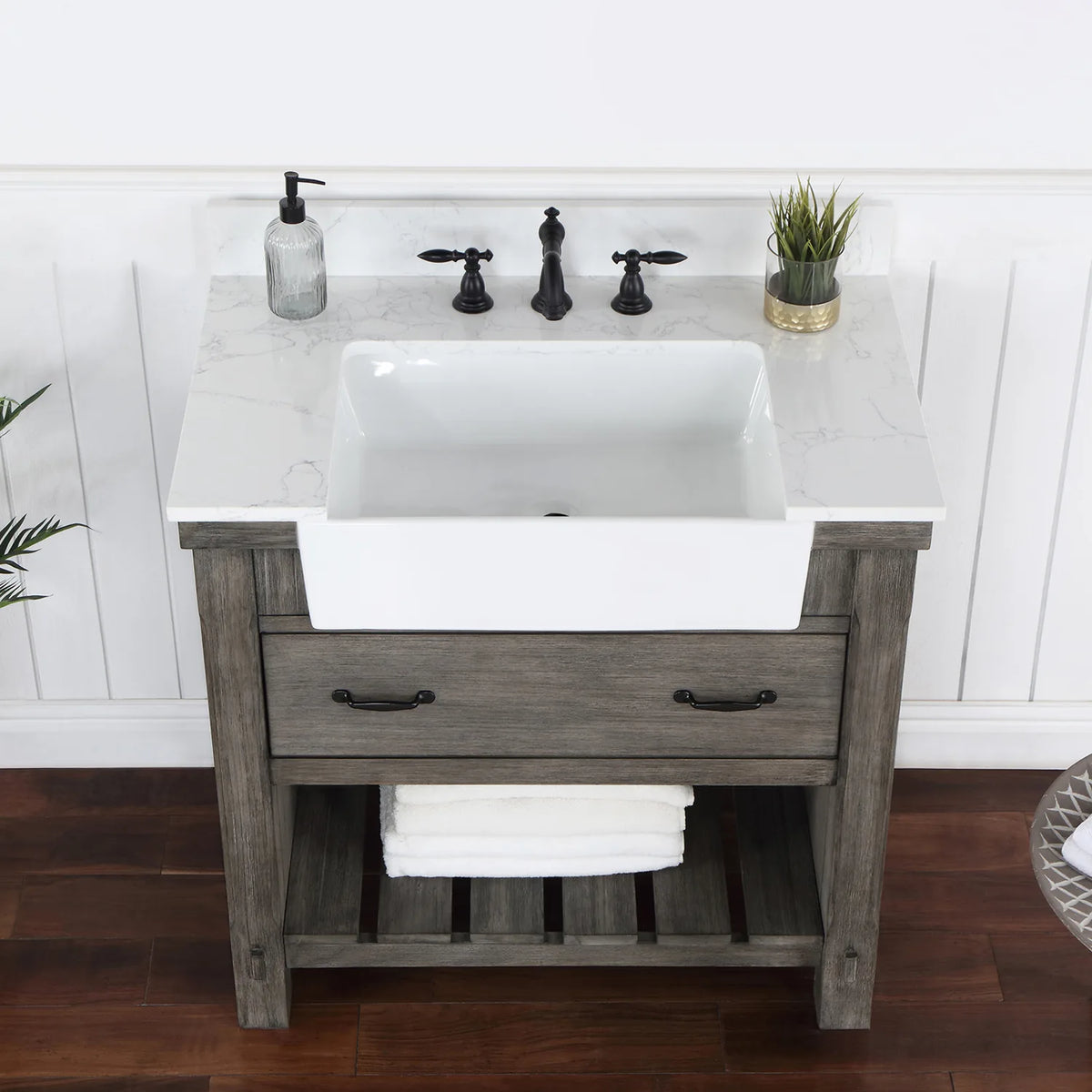 Overhead crop: stone surface, white basin, black pulls on the drawer below