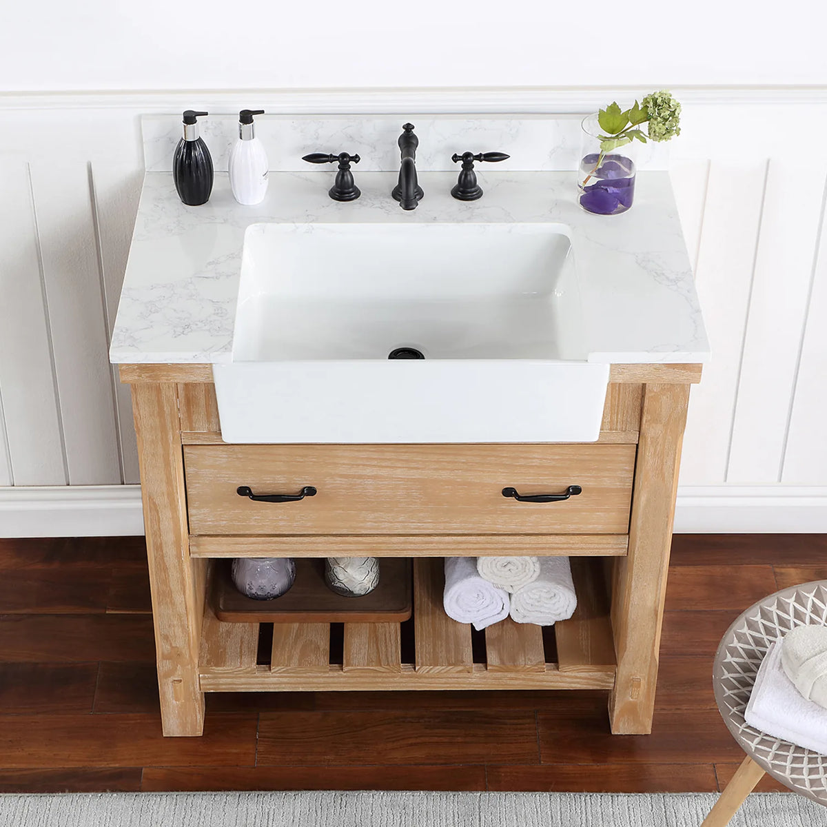 Overhead crop: stone surface, white basin, black pulls on the drawer below