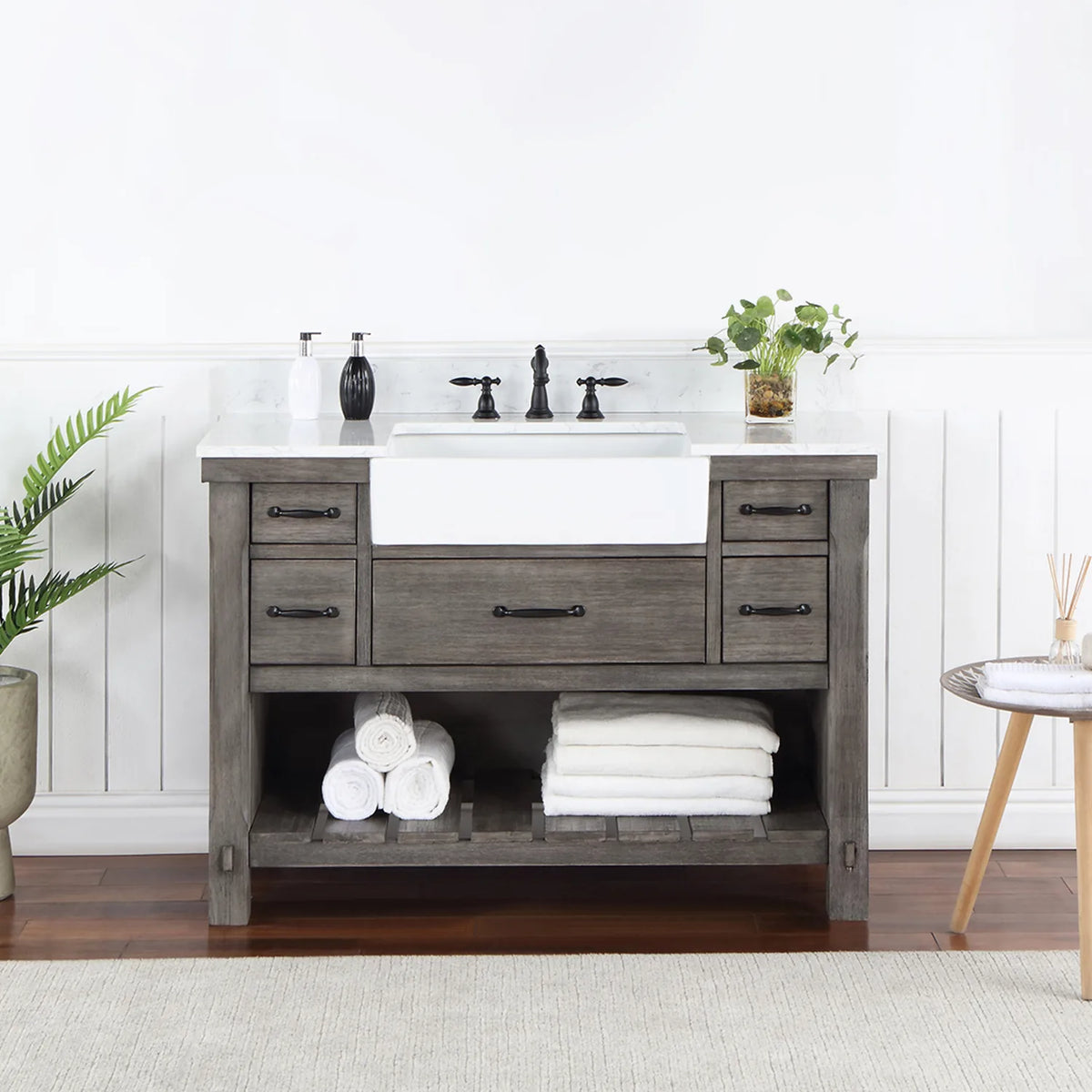 Bathroom setting with white paneled wall, fern and side table beside the vanity