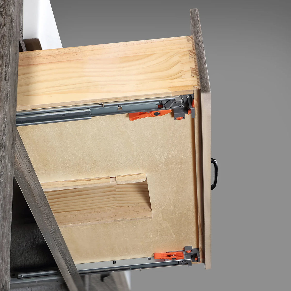 Cutaway of a drawer showing the metal slide and dovetail corner on a grey backdrop