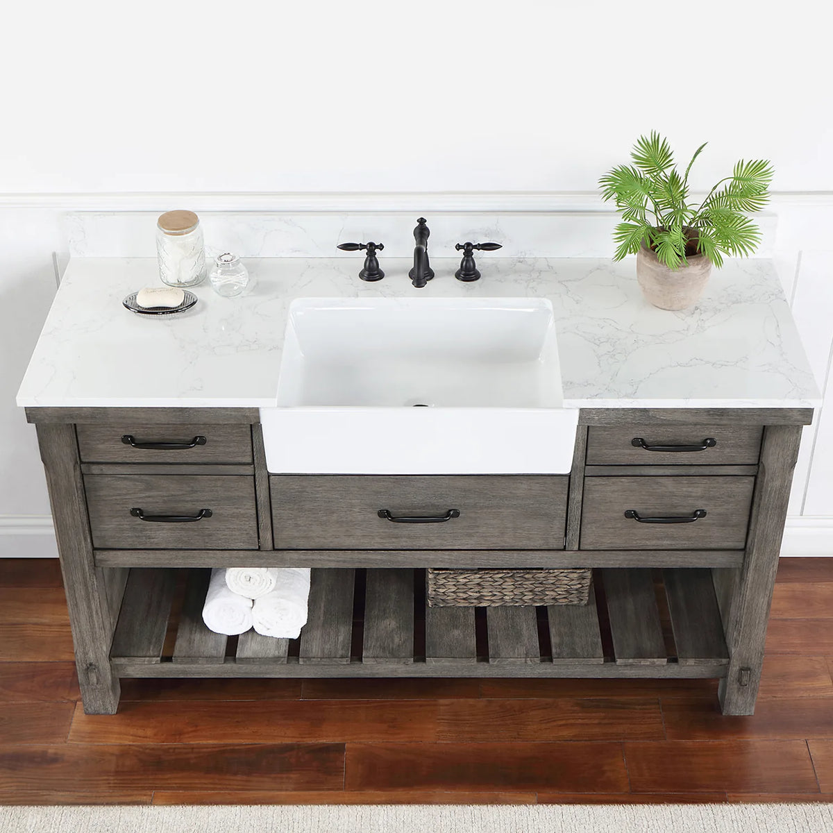 Overhead crop: stone surface, white basin, black pulls on the drawers below