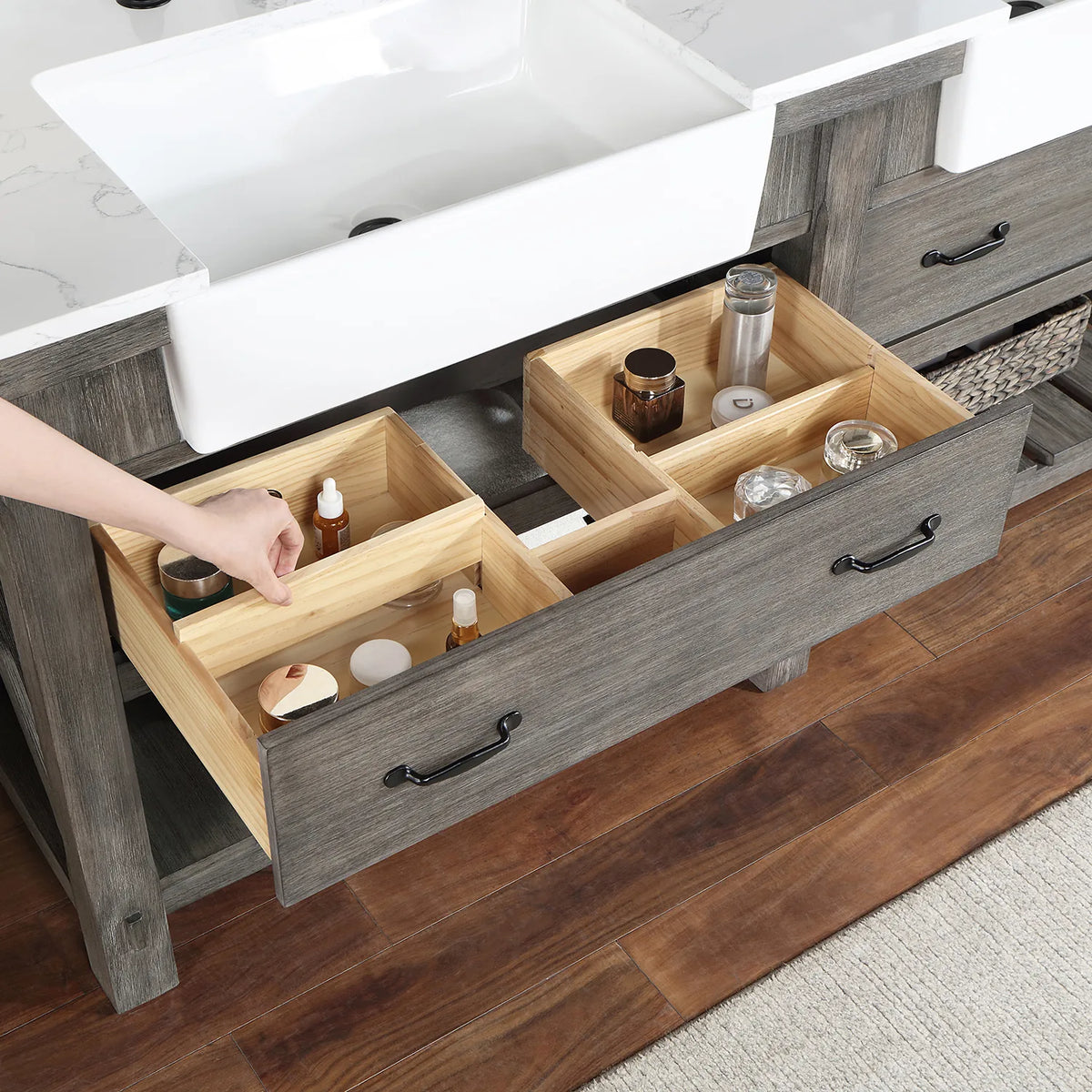 Hand adjusting wood dividers inside a pulled-out drawer