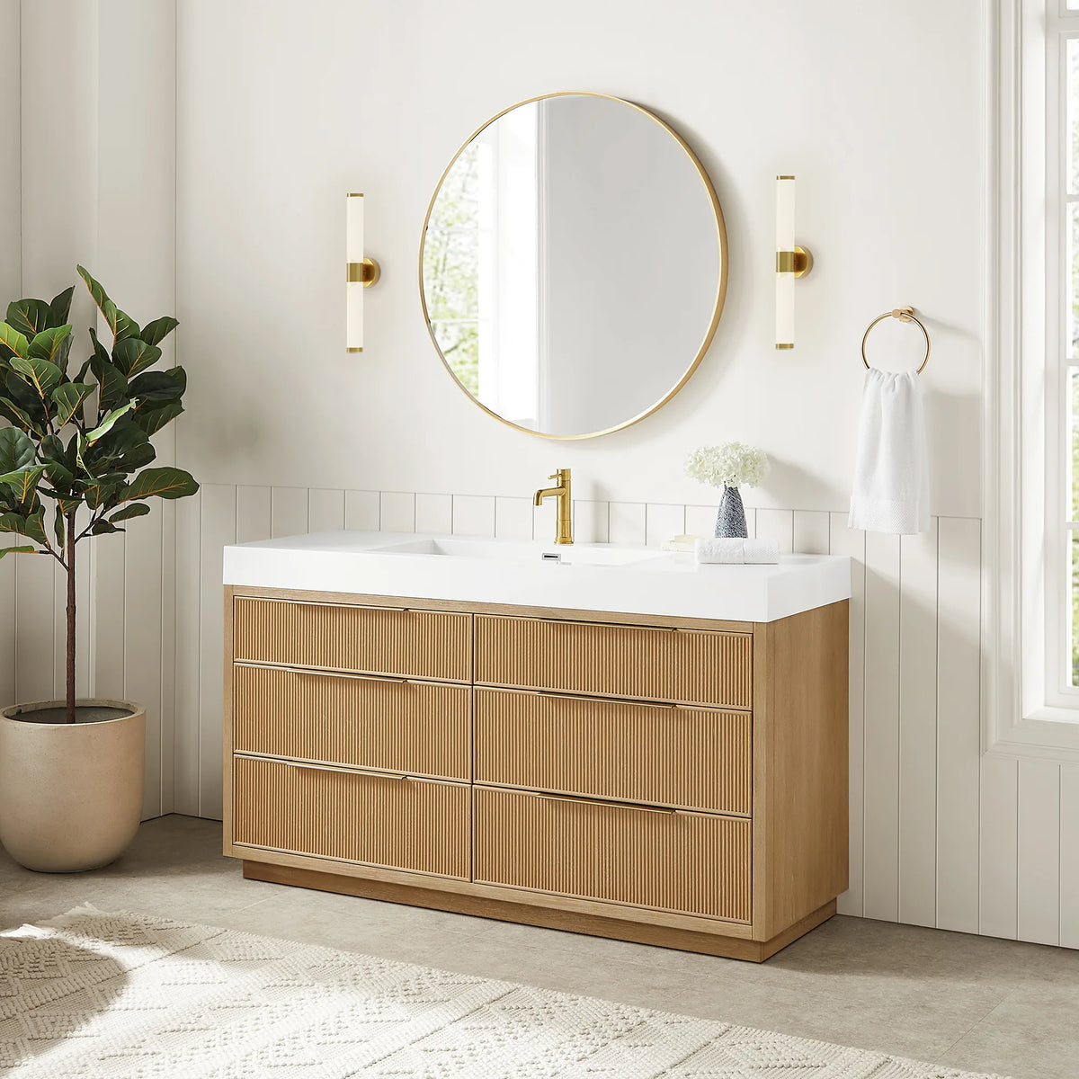 Bath scene with the 60-inch single vanity under its matching circular mirror and sconces, plus a leafy plant and a window