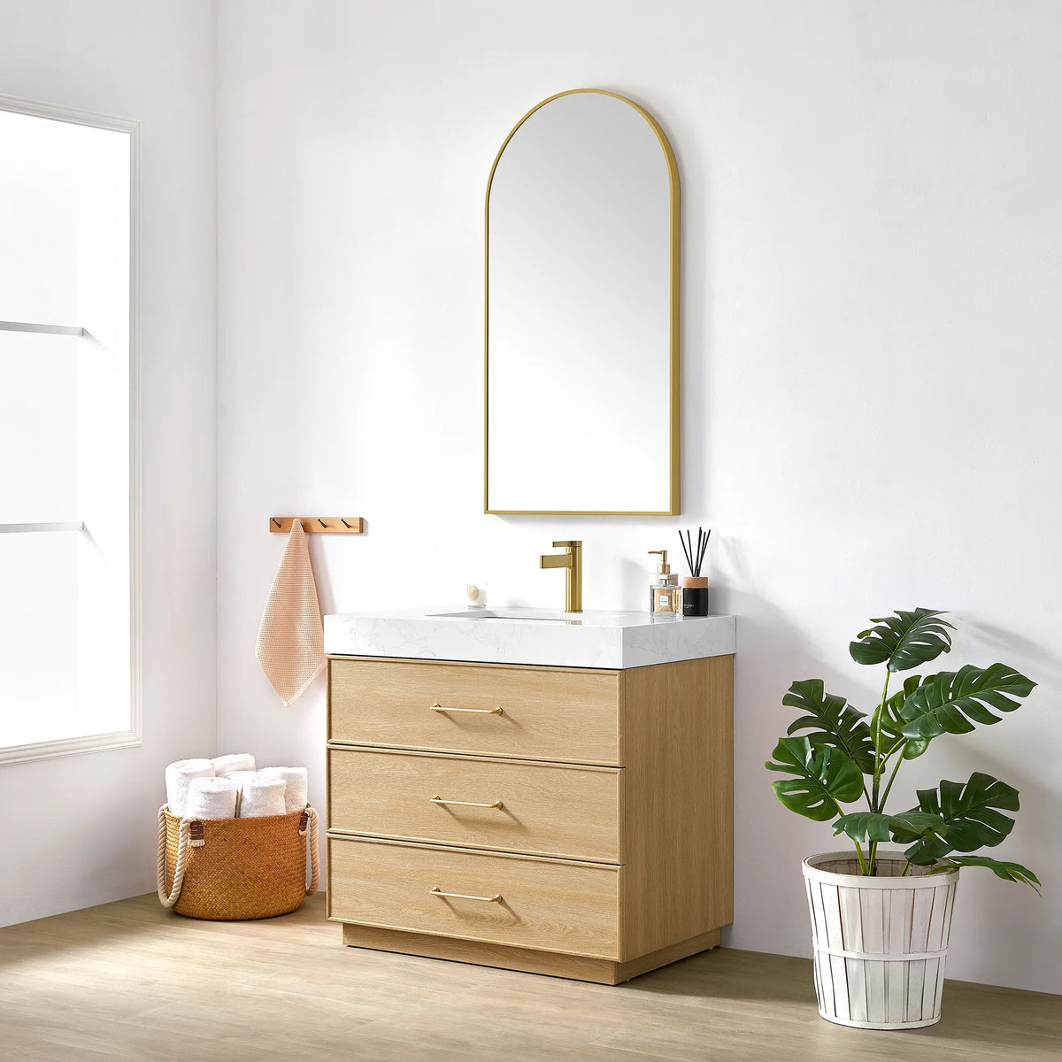 Bathroom setting with the 36 inch vanity, gold-framed mirror and a potted plant by a bright window