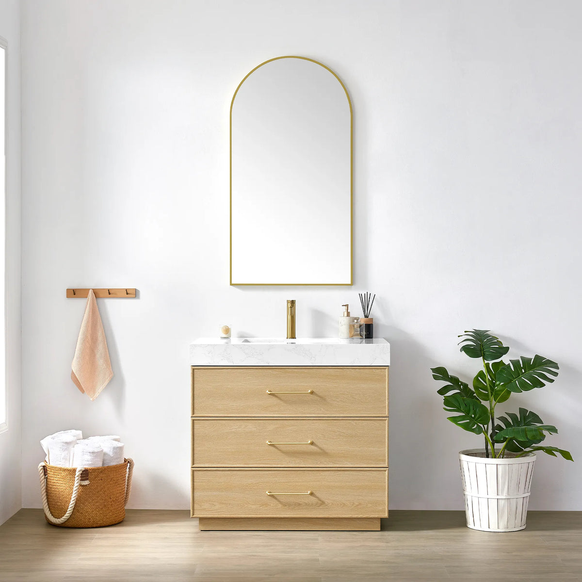 Dark Oak vanity and matching arched mirror with a slim gold frame, styled with towels and a plant
