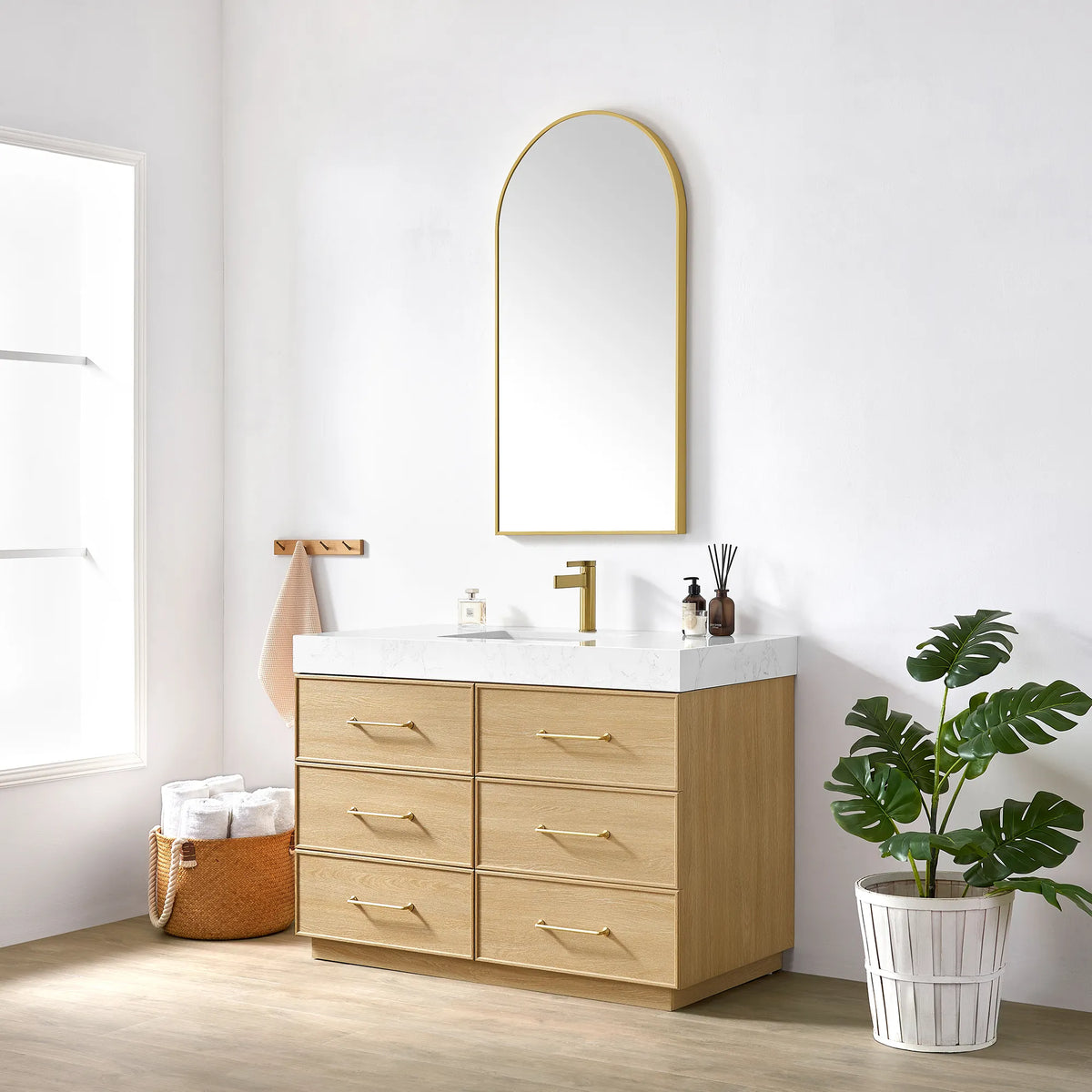 Bathroom setting with the 48 inch vanity, gold-framed mirror and a potted plant by a bright window