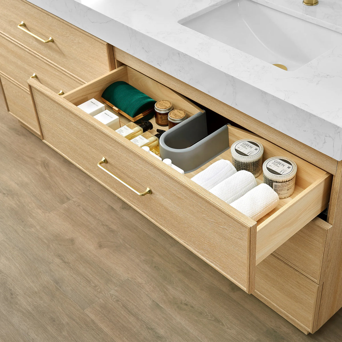 Open Dark Oak drawer with a gray divider tray and towels laid in place