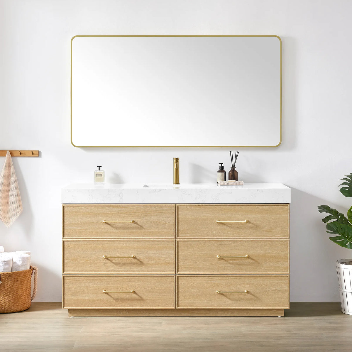 Dark Oak vanity and matching rounded-rectangle mirror with a slim gold frame, styled with towels and a plant