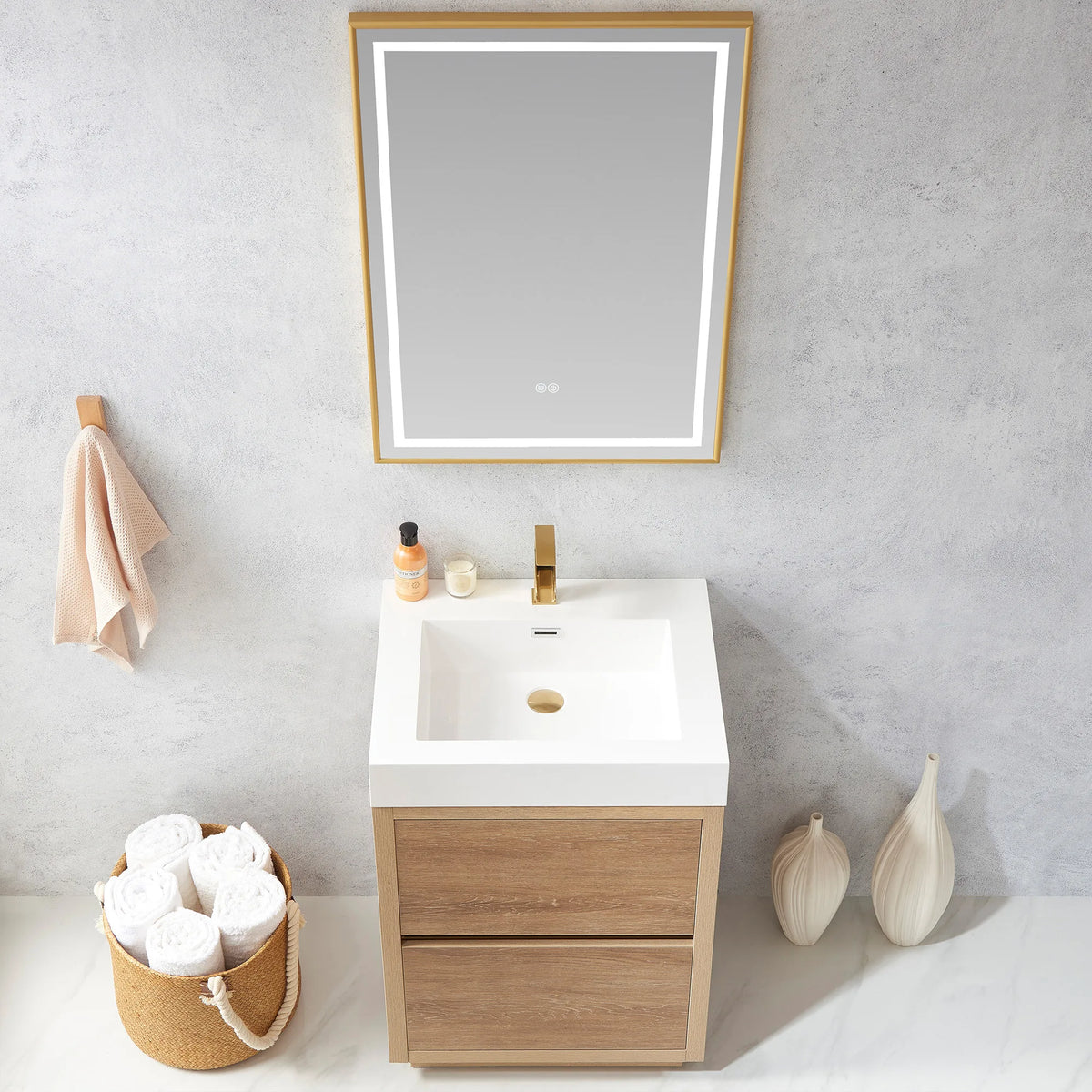 Medium shot looking down at the integrated white sink, LED mirror above, towel basket at left