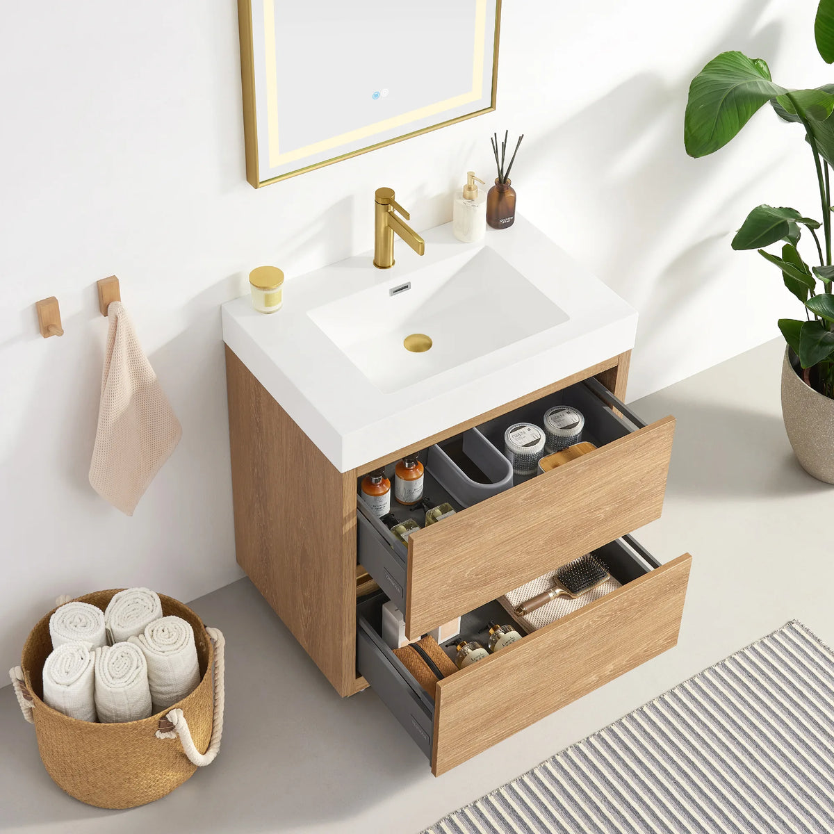 Vanity with drawers open and their contents visible, mirror above, plant at the right