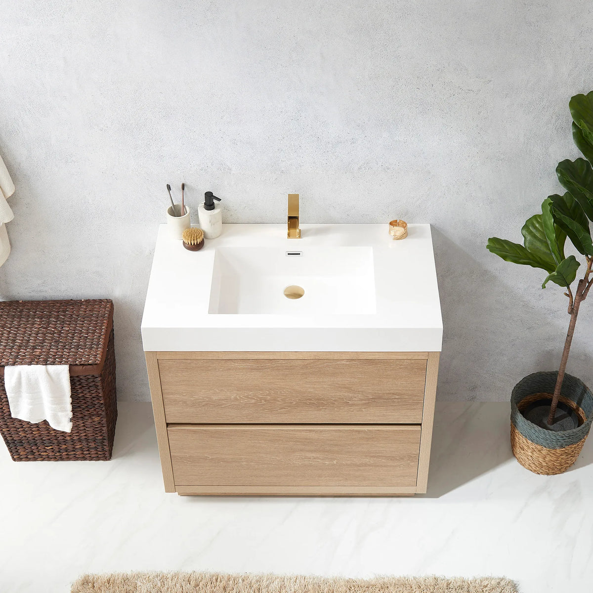 Overhead view of the white integrated sink with hamper at left and potted plant at right