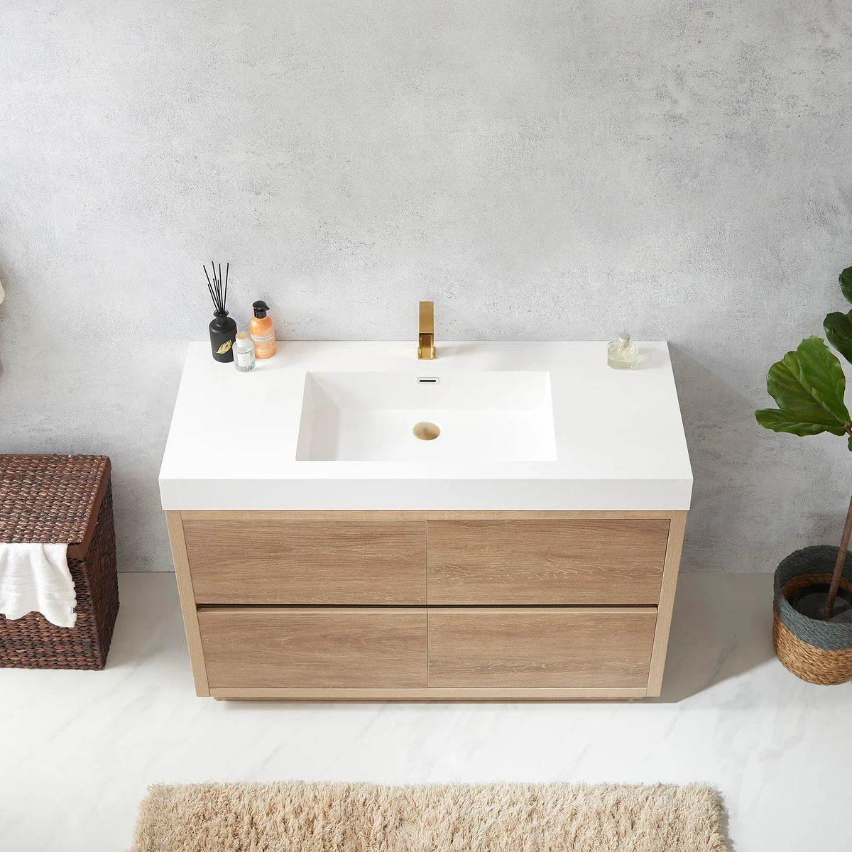Overhead view of the white integrated sink with diffuser and soap bottle, hamper at left
