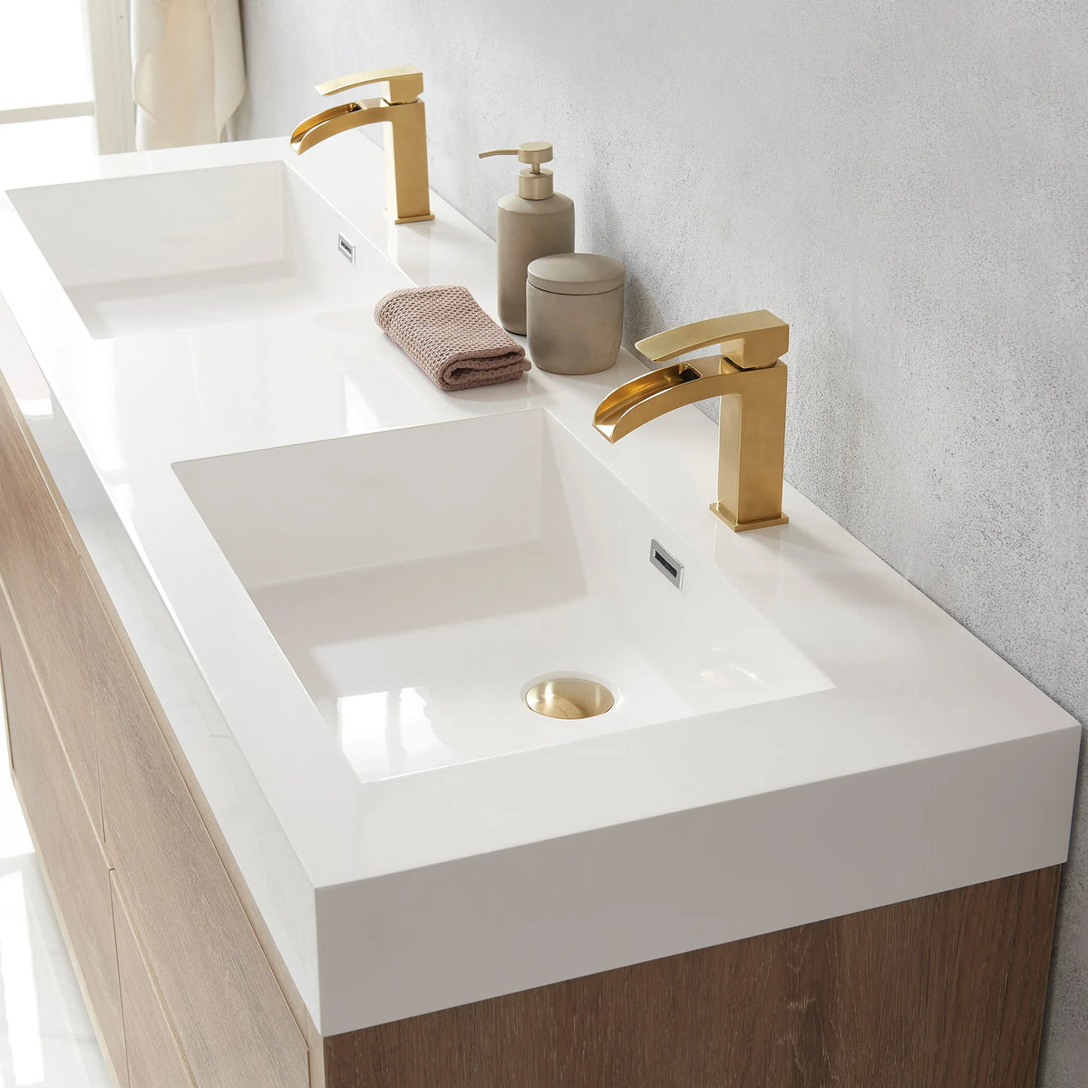 Close-up of the double sink top with its drain, small jars and a folded hand towel