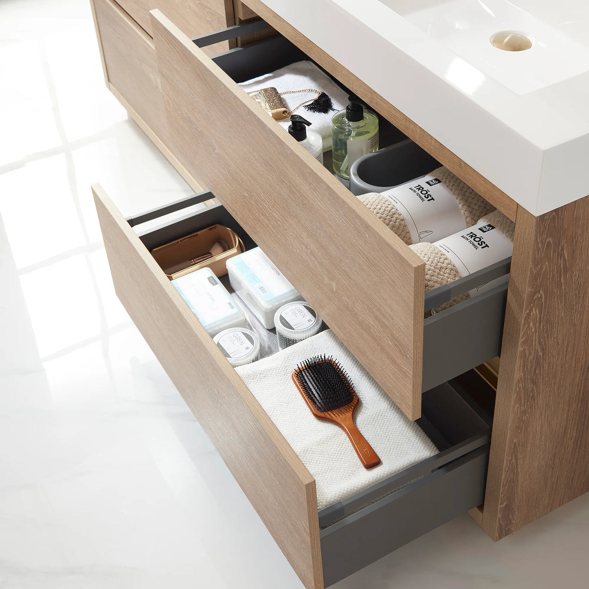Close-up of open drawers with a hairbrush, boxes and toiletries, gray drawer sides
