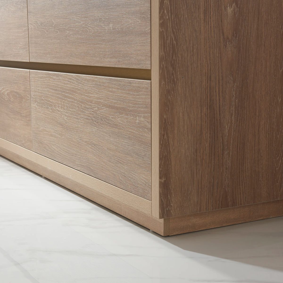 Close-up of oak front panels, pull recess and plinth base, low-angle view