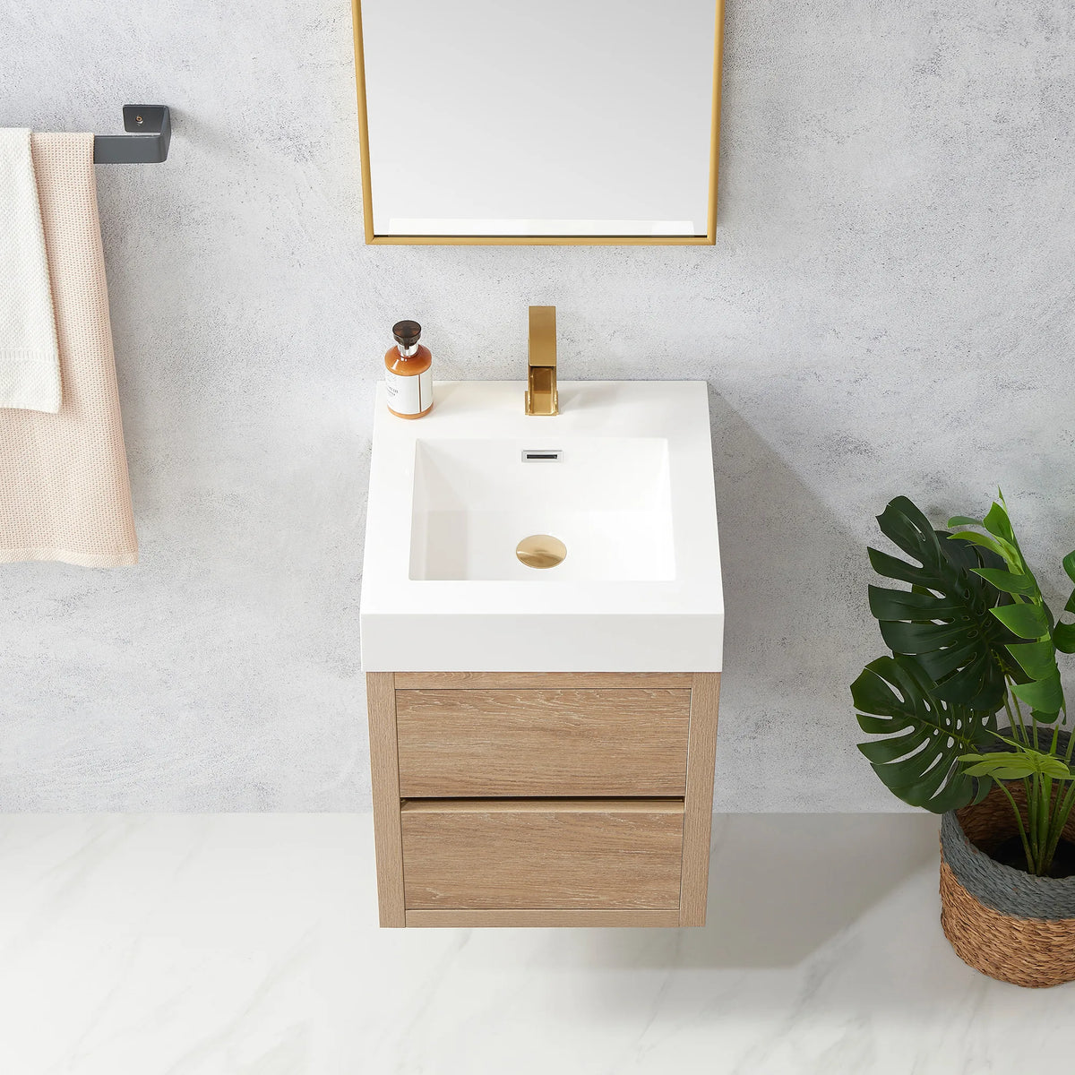 Detail of the integrated sink top and cabinet front, a plant and towel behind
