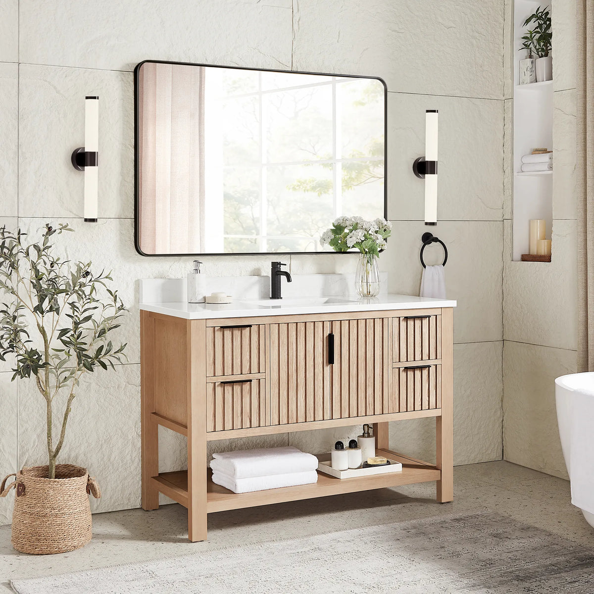 Second angle: 48-inch cabinet in Aged Natural Oak with a matching rectangular mirror in a black frame and a plant