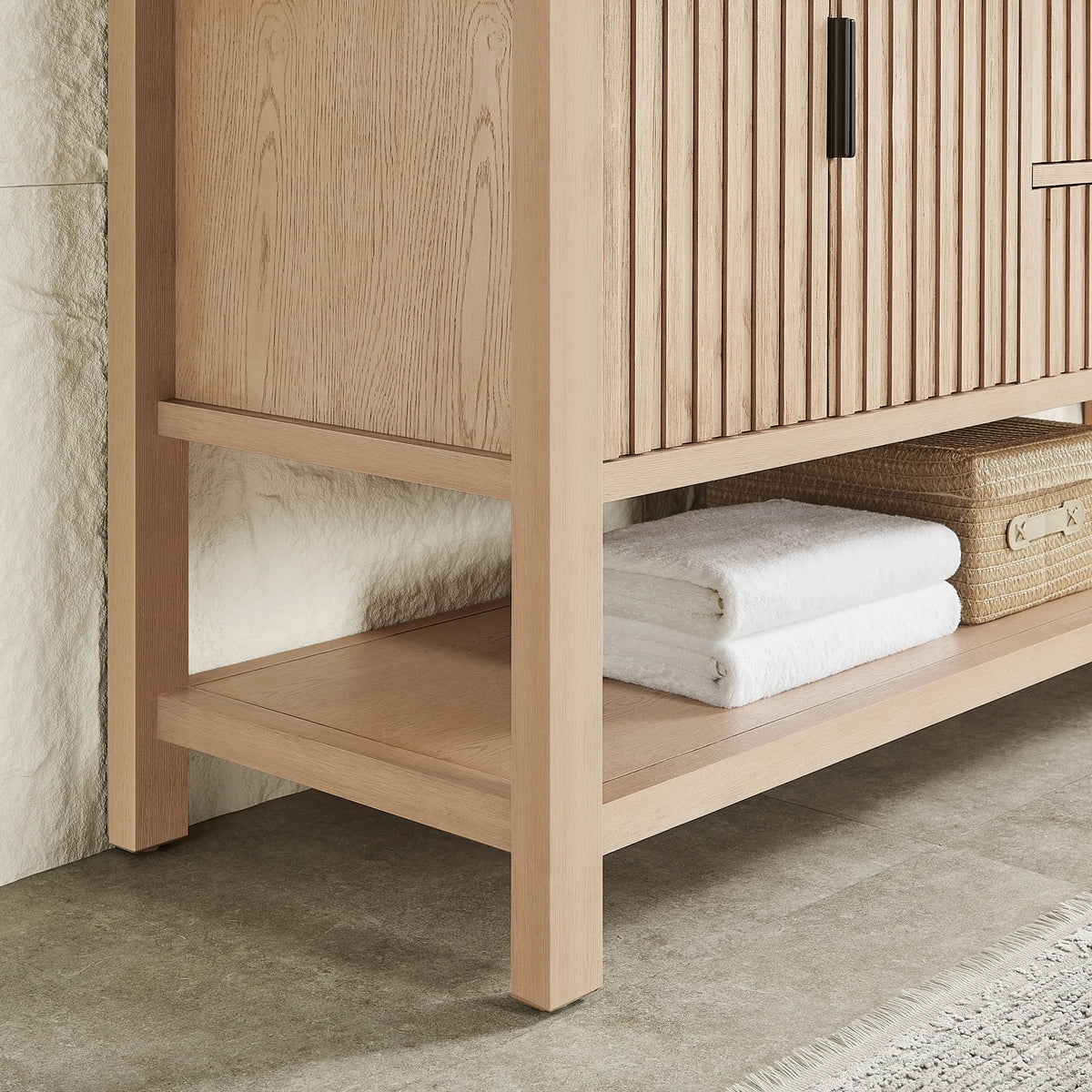 Shelf storage under a 60-inch Aged Natural Oak cabinet, with towels and a basket