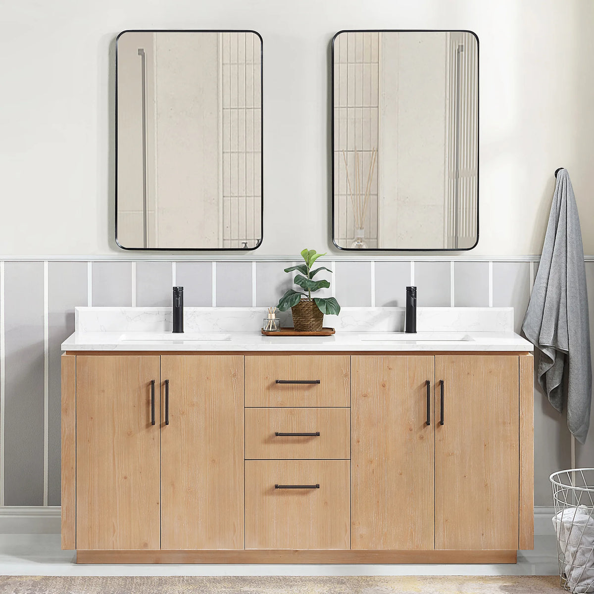 Room scene with the matching mirrors over the vanity, a hanging towel and a wire basket