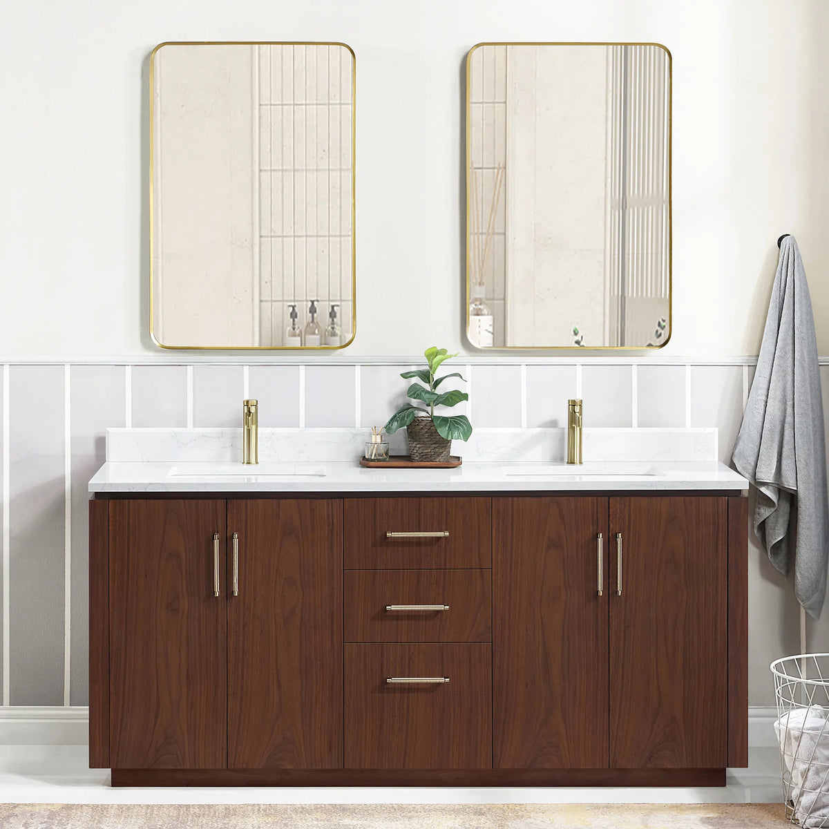 Wide room view of the double vanity with mirrors, a plant at center and a basket at the lower right