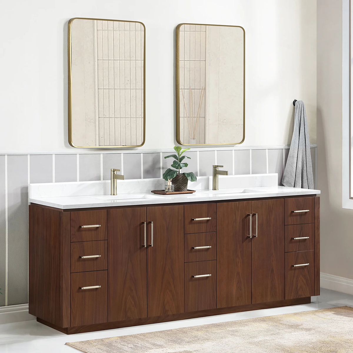 Angled room scene of the double vanity with mirrors, a plant tray on top and a rug on the floor
