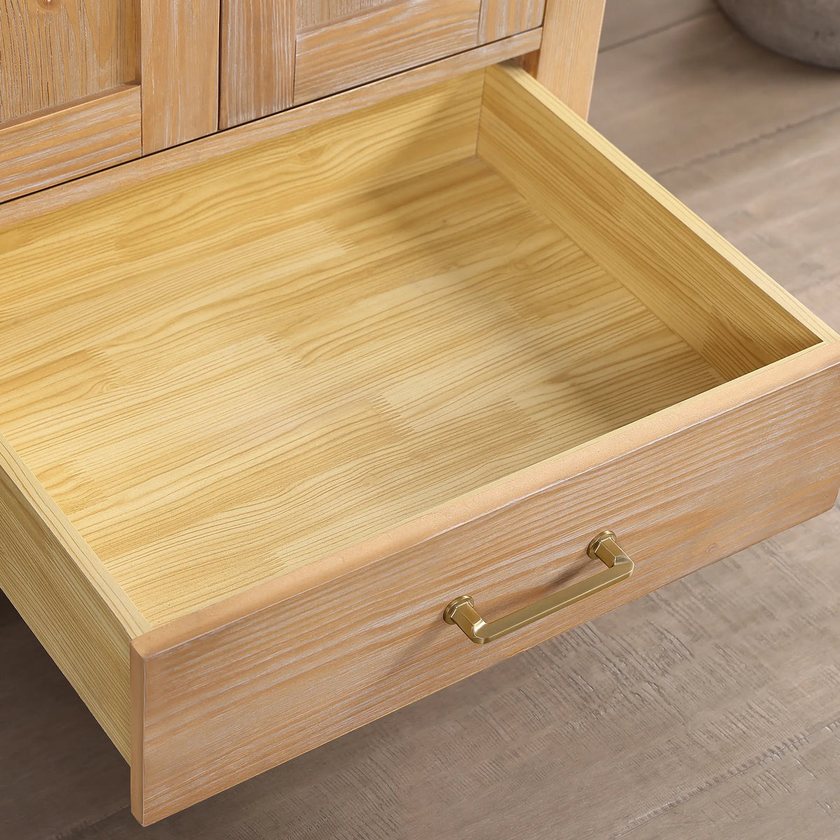 Light wood drawer box open, gold bar pull on the front