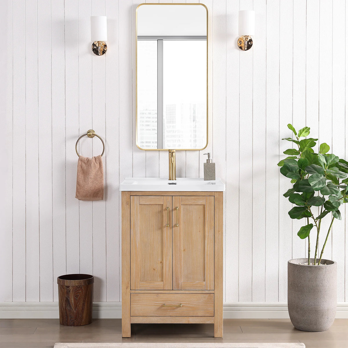 Gold mirror hung over the vanity in a bathroom with wall sconces on either side