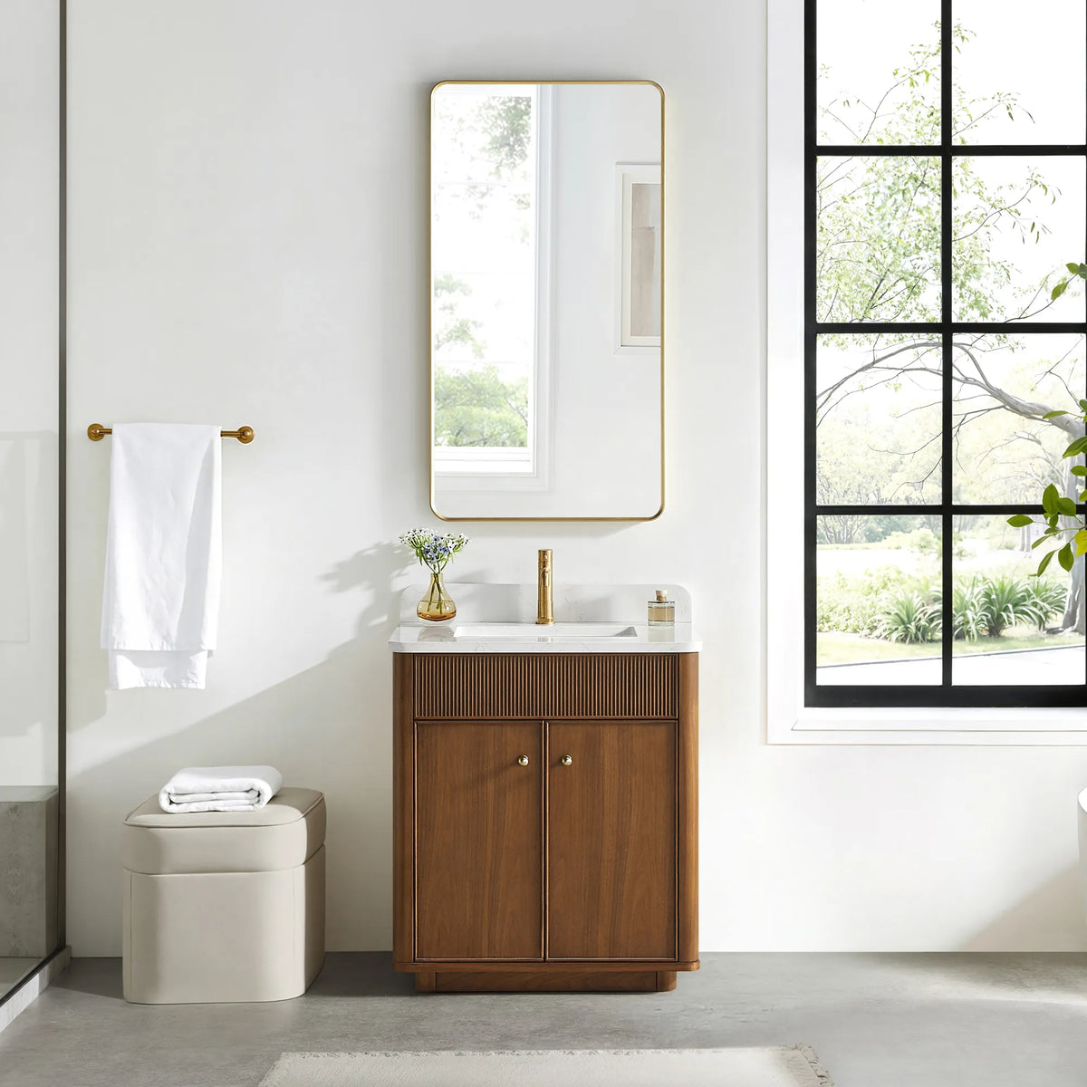 Matching tall rounded-rectangle gold mirror above the Natural Walnut vanity in a bathroom with a black-framed window