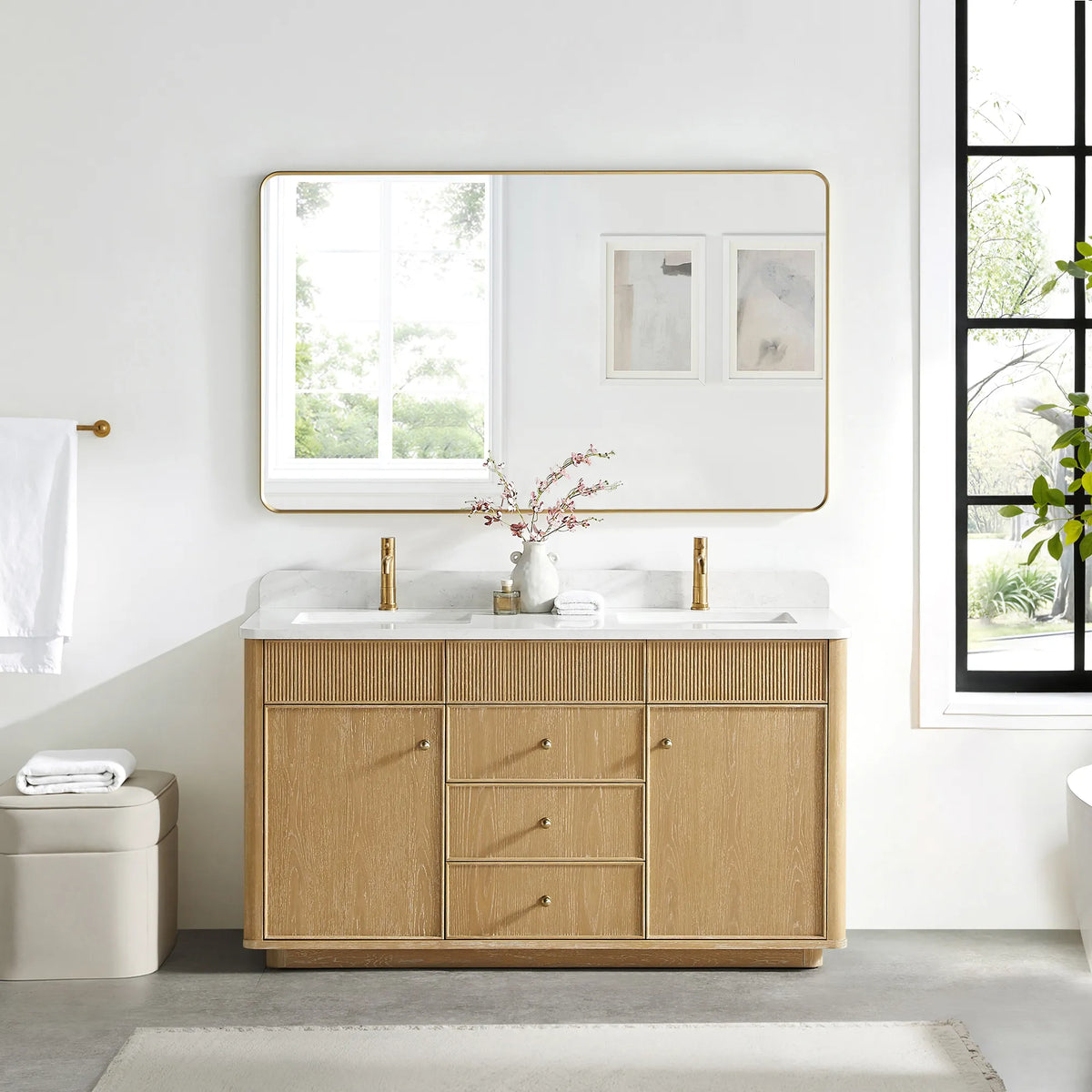 Matching wide rounded-rectangle gold mirror above the Washed Ash Grey vanity in a bathroom with a black-framed window