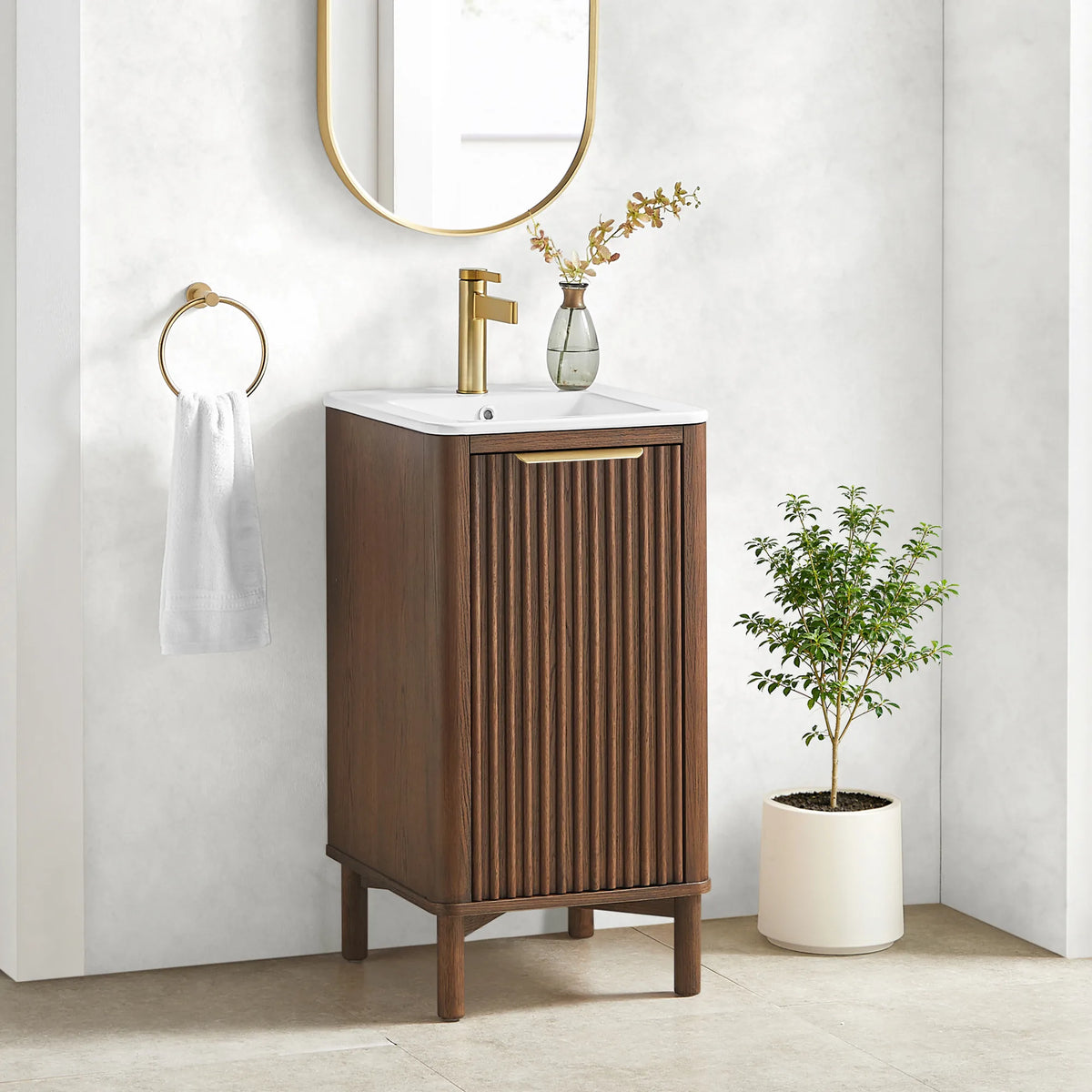 Room shot of the 18-inch Aged Dark Brown Oak vanity, ribbed door facing out, a white pot of greenery beside it