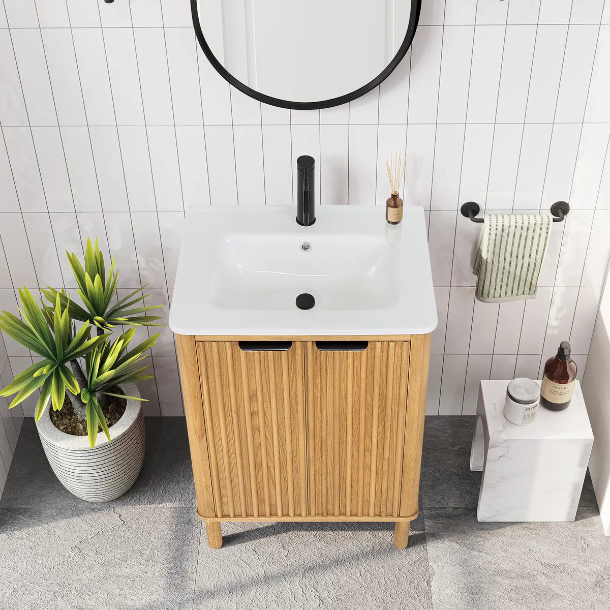 High-angle look at the compact 24-inch single vanity, two ribbed doors with black pulls under the one-piece top