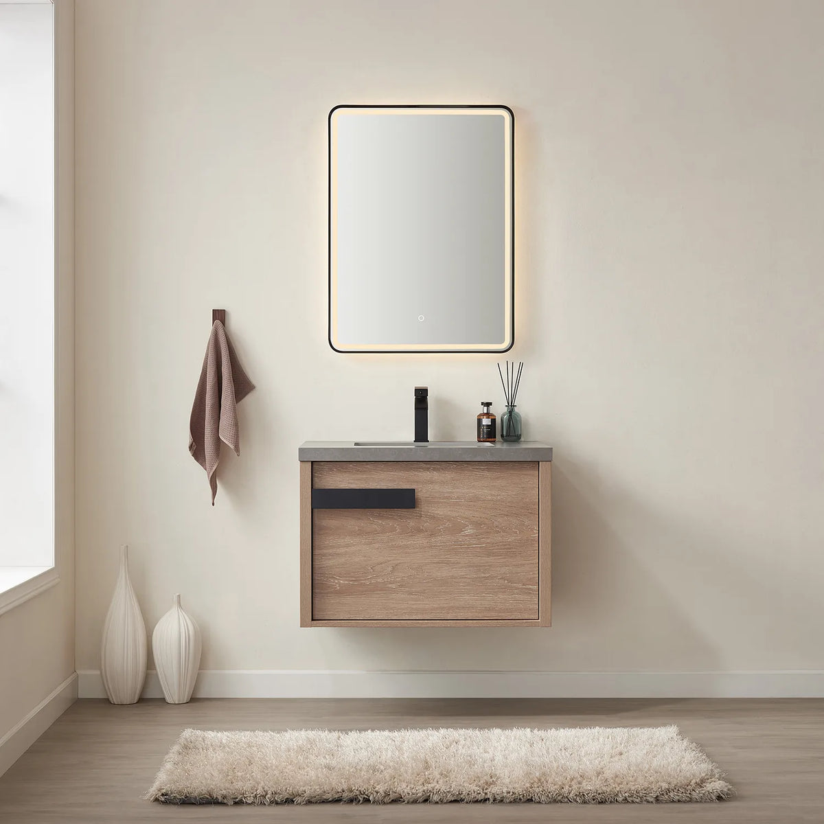 Backlit mirror and wall-hung vanity in a bright neutral bathroom