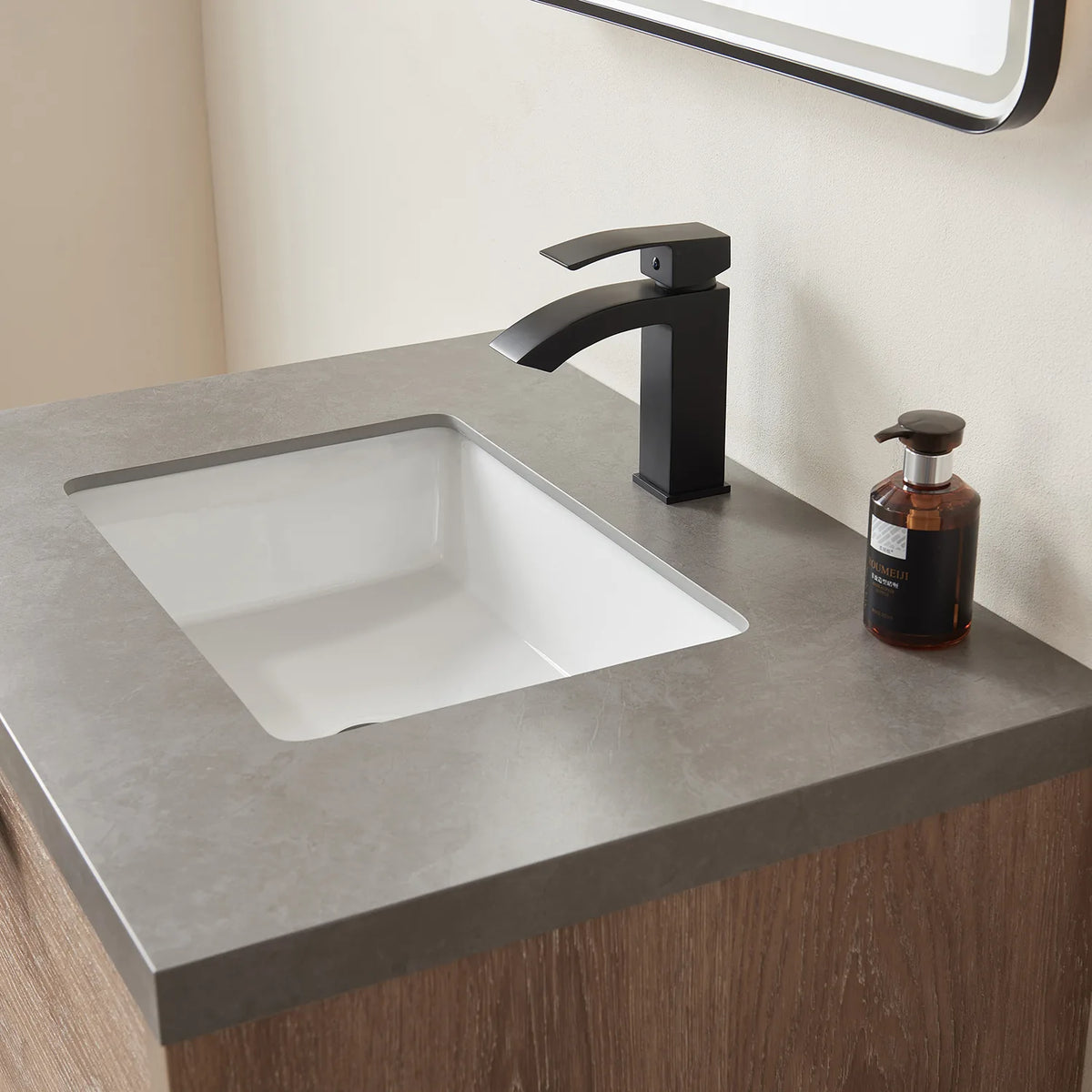 Tight crop of the basin and tall faucet with part of the mirror frame above