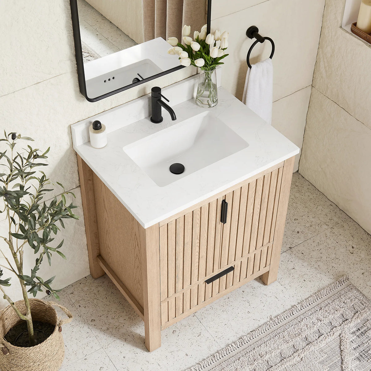 Top-down angle: a stone-composite top and ceramic undermount basin on the 30-inch Aged Natural Oak cabinet