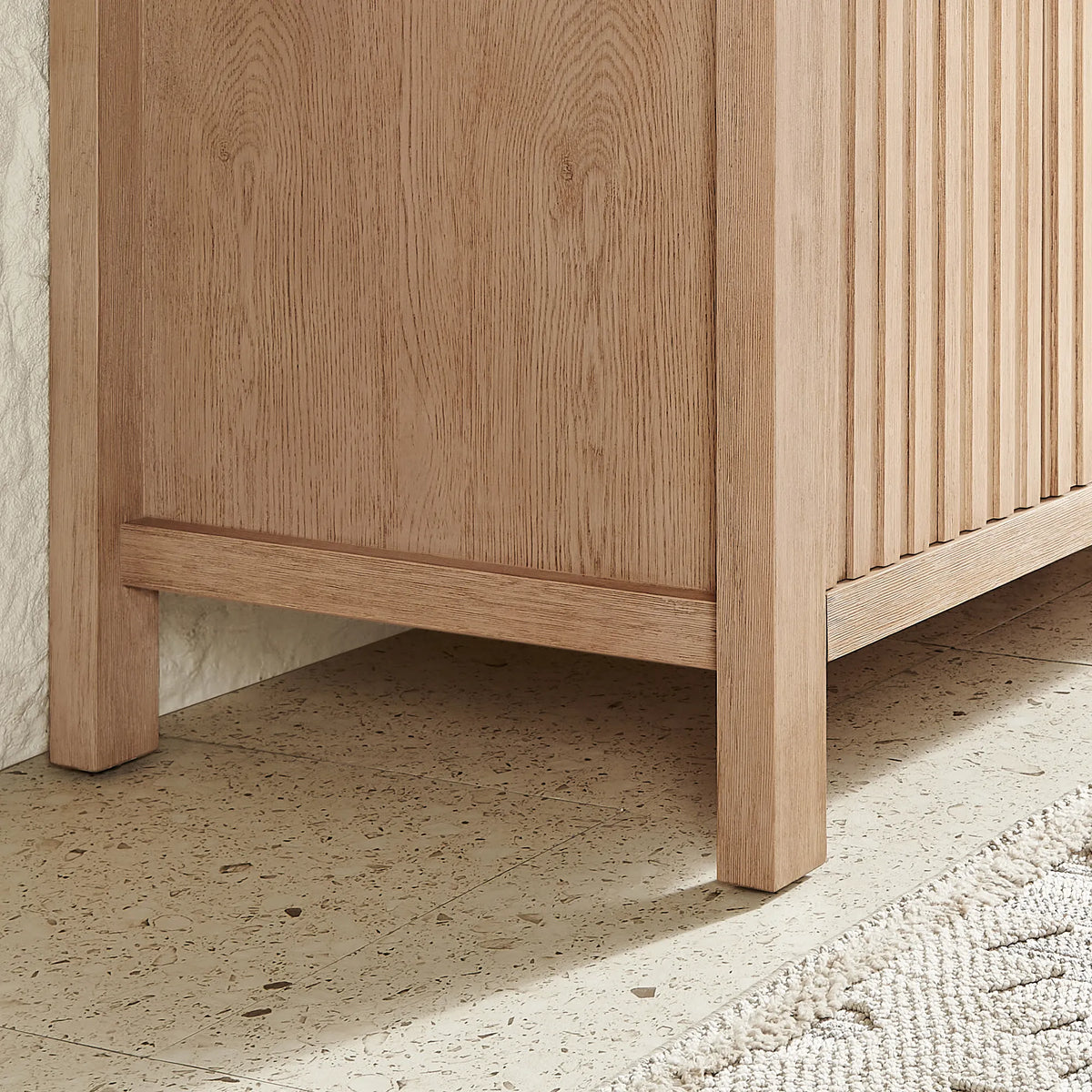 Base detail, 30-inch cabinet: corner leg and grooved side panel in Aged Natural Oak