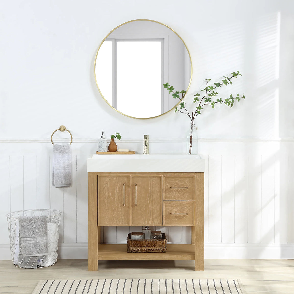 Bathroom scene: Washed Ash Grey cabinet, circular mirror above and a striped rug underfoot, 36-inch model
