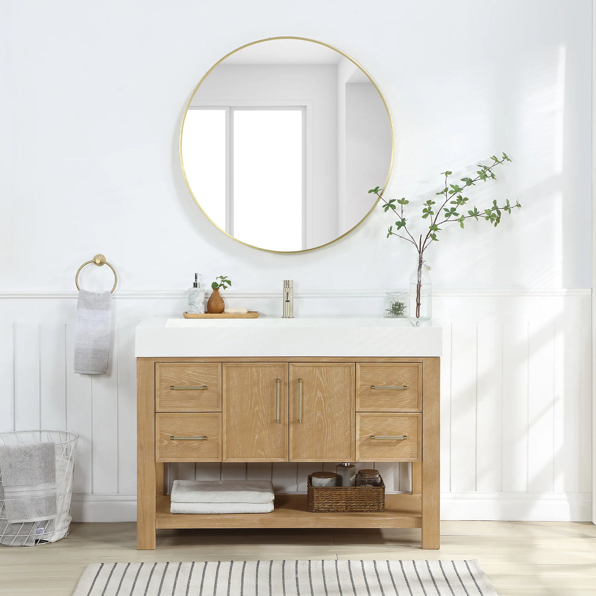 Bathroom scene: Washed Ash Grey cabinet, circular mirror above and a striped rug underfoot, 48-inch model