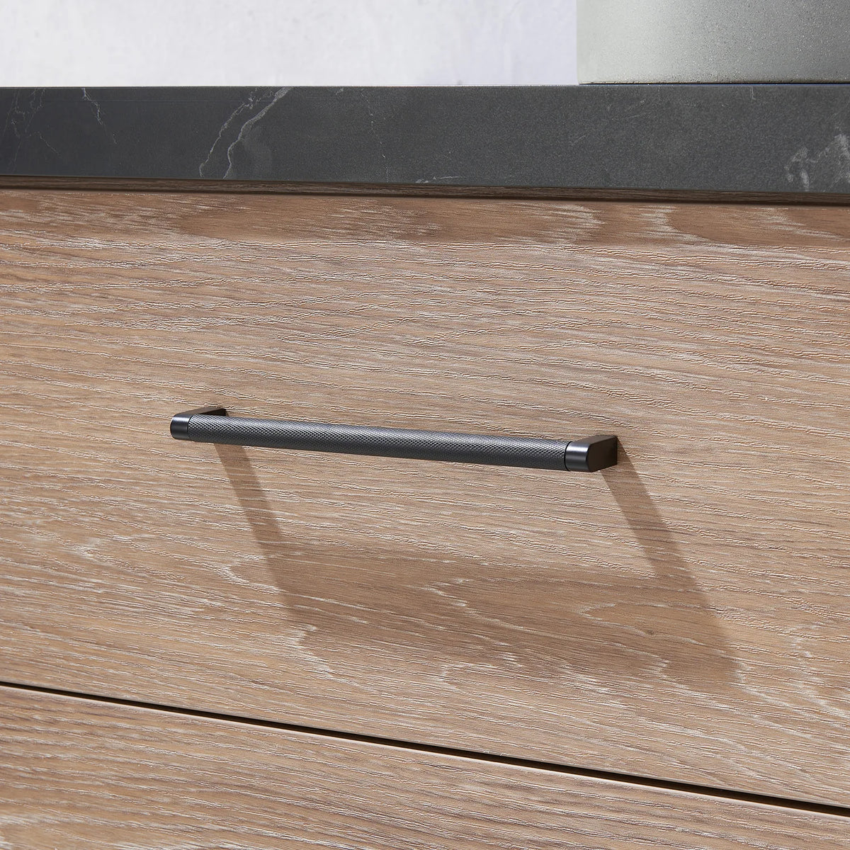 Elongated black pull across the oak drawer face
