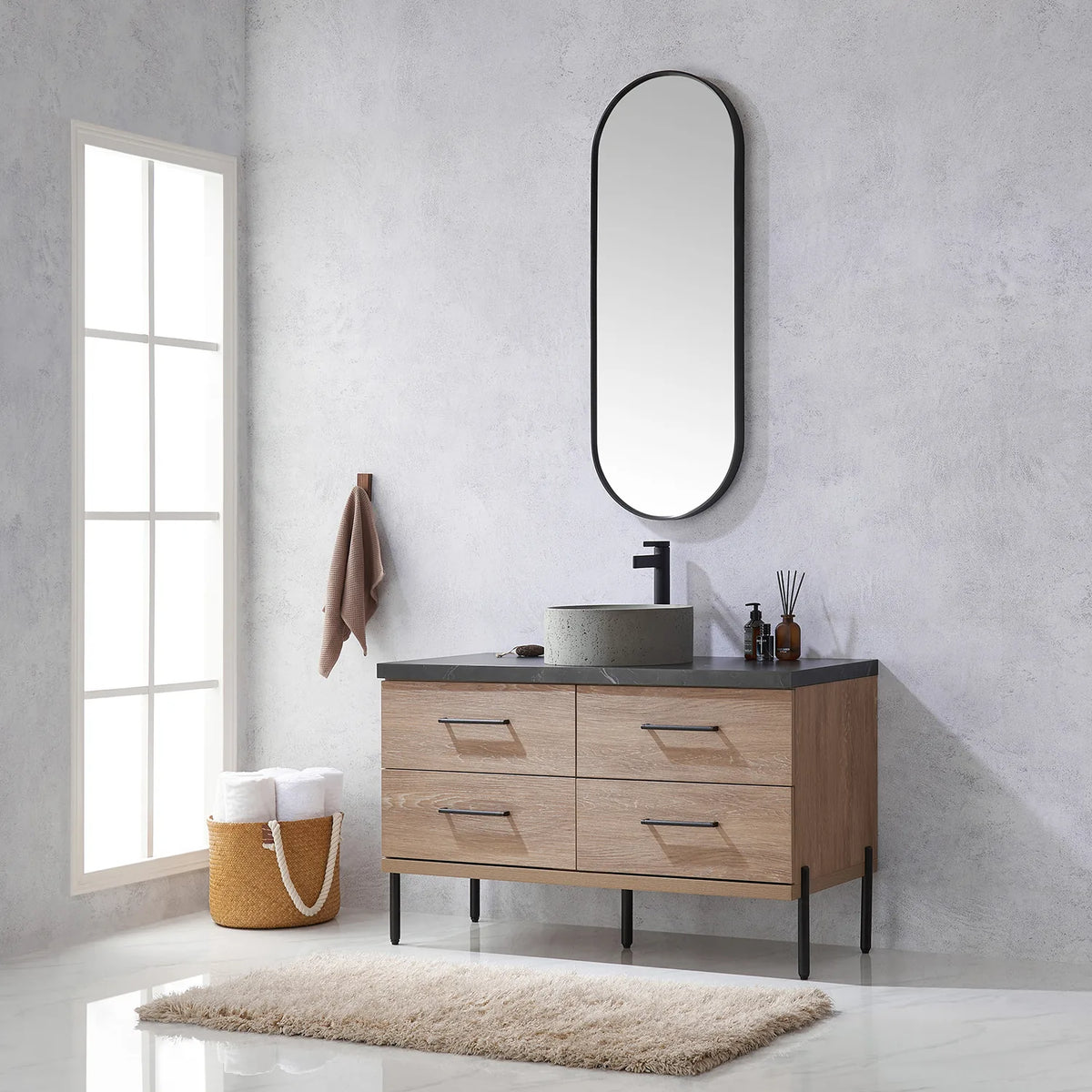 Plush rug, tall window and oval mirror above the oak vanity