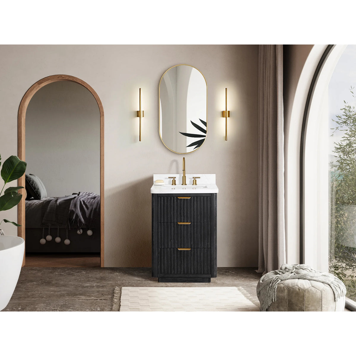 Wide view of the vanity under an oval mirror with arched windows, a rug and a pouf at the right