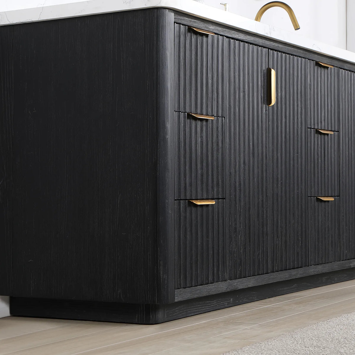 Corner view of the freestanding vanity showing fluted panels, door and drawer fronts and a plinth base