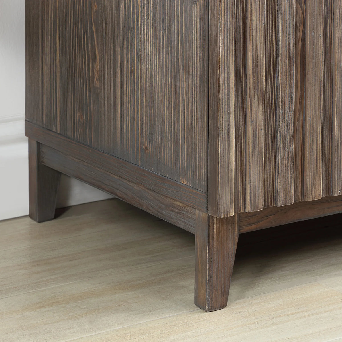 Grooved door fronts above an angled leg, Spruce Aged Brown finish, shot near the floor