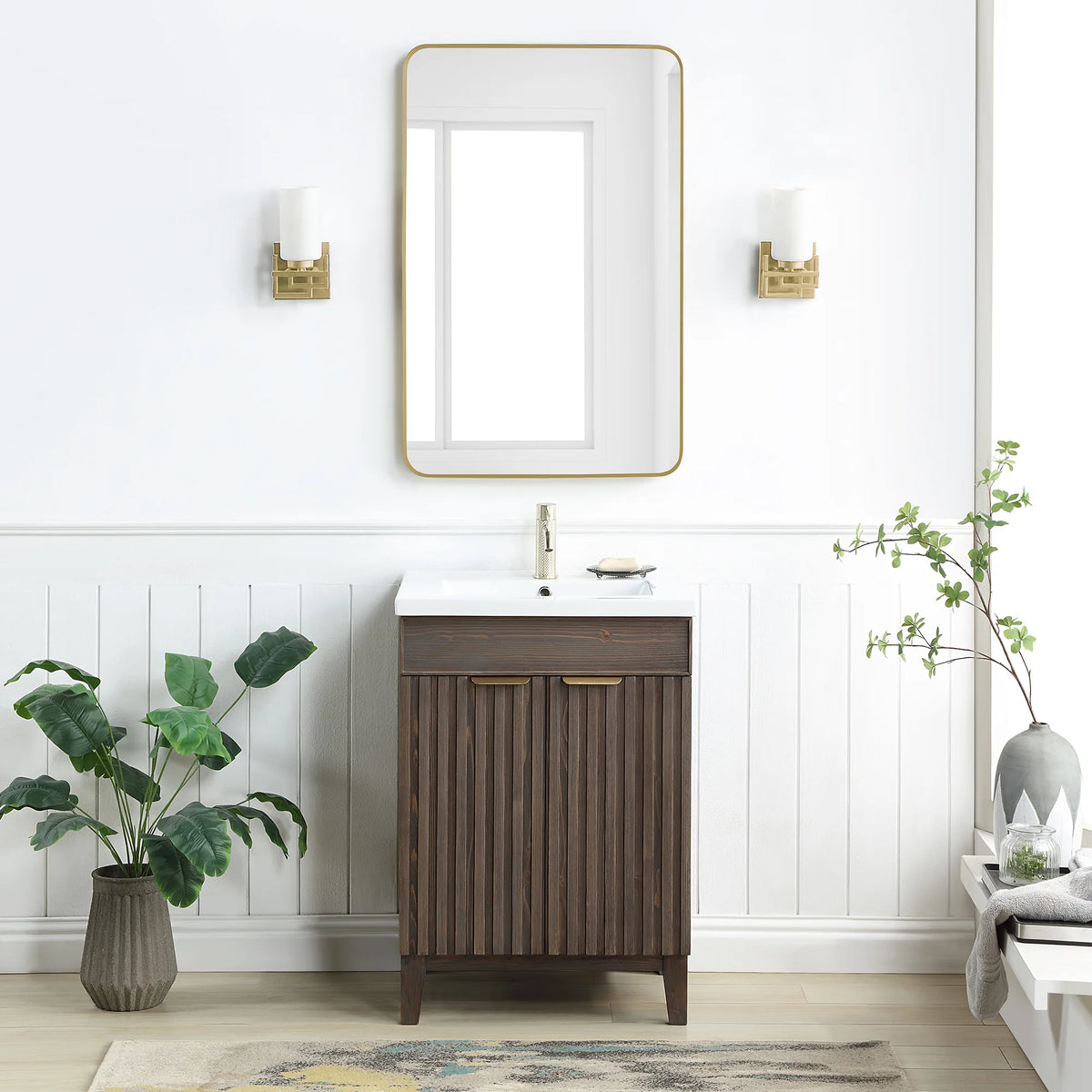 A bath with white paneled walls: 24-inch single vanity in Spruce Aged Brown under a rectangular wall mirror